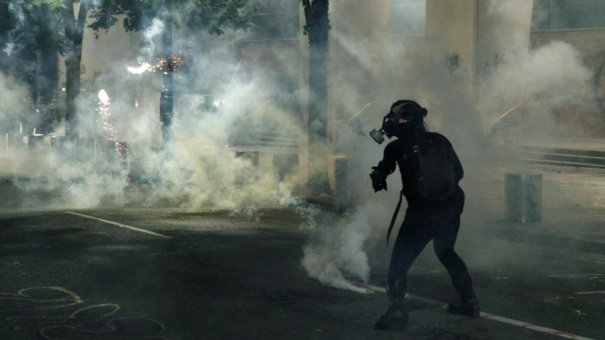 PORTLAND, OREGON, USA: Tear gas and fireworks mix as Black Lives Matter supporters demonstrate in Portland, Oregon on July 4, 2020 for the thirty-eighth day in a row at Portland's Justice Center and throughout Portland, with a riot declared about 12.20 am on July 5. CS tear gas and less-lethal weapons were used, and multiple arrests were made. (Photo by John Rudoff/Anadolu Agency via Getty Images)