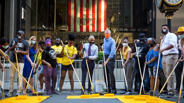 Bill de Blasio, mayor of New York, center right, and Reverend Al Sharpton, president and founder of the National Action Network Inc. (NAN), center, paint a 'Black Lives Matter' mural along Fifth Avenue in front of Trump Tower in New York, U.S., on Thursday, July 9, 2020.
