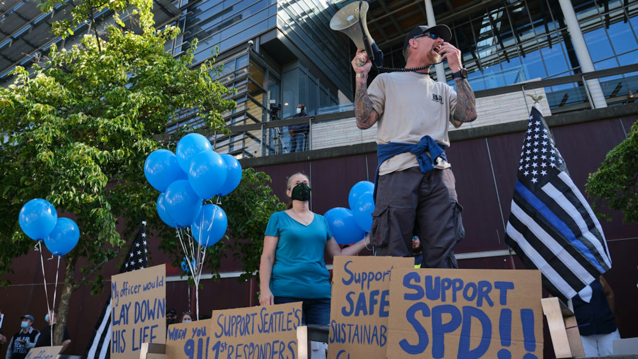 A former law enforement officer leads a chant during a Rally to Support Seattle Police Department rally in front of City Hall on July 15, 2020 in Seattle, Washington.