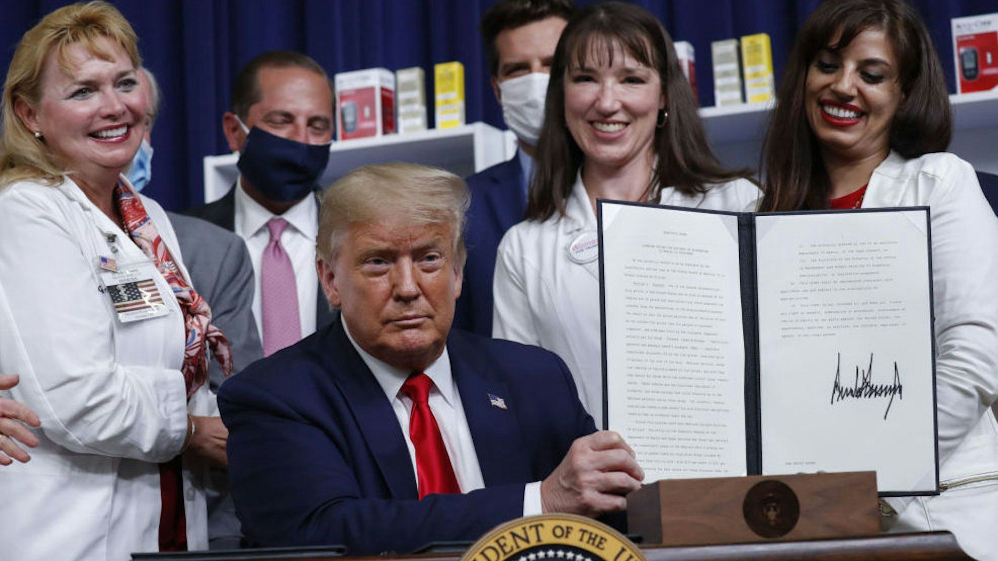 U.S. President Donald Trump holds an executive order on lowering drug prices after being signed during a ceremony in the Eisenhower Executive Office Building in Washington, D.C., U.S., on Friday, July 24, 2020.