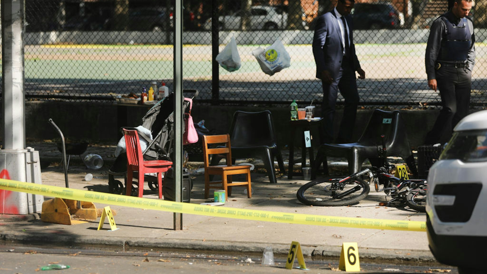 Police ballistic markers stand besides a child's chair and bicycle at a crime scene in Brooklyn where a one year old child was shot and killed on July 13, 2020 in New York City.