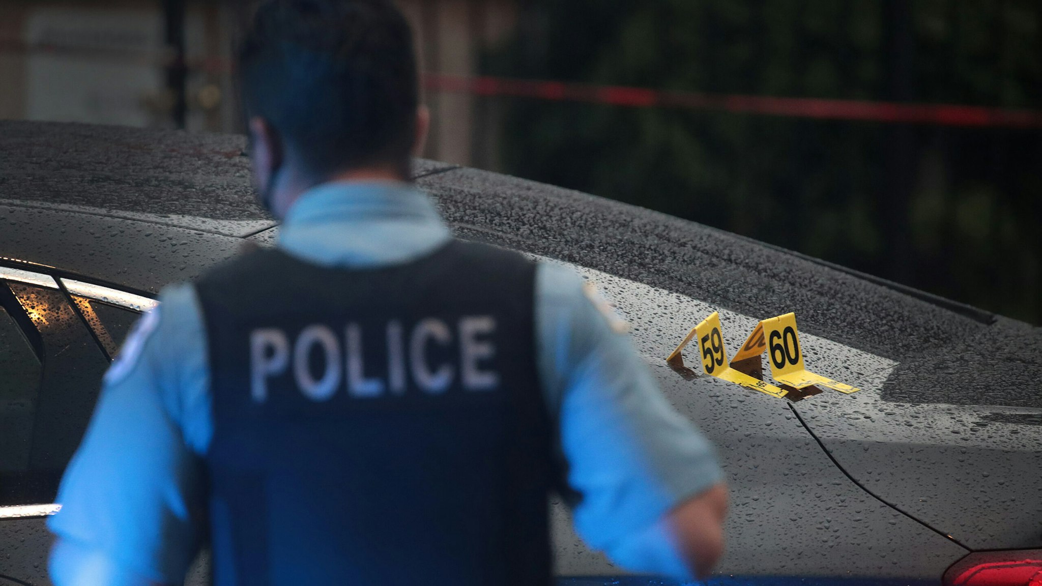 CHICAGO, ILLINOIS - JULY 21: Shell casings labeled 59 and 60 rest on a bullet-riddled car as police investigate the scene of a shooting in the Auburn Gresham neighborhood on July 21, 2020 in Chicago, Illinois. At least 14 people were transported to area hospitals after several gunmen, believed to be in the car, opened fire on mourners standing outside a funeral home. The car crashed and the occupants fled after mourners returned fire. More than 2000 people have been shot and more than 400 have been murdered in Chicago so far this year. (Photo by Scott Olson/Getty Images)