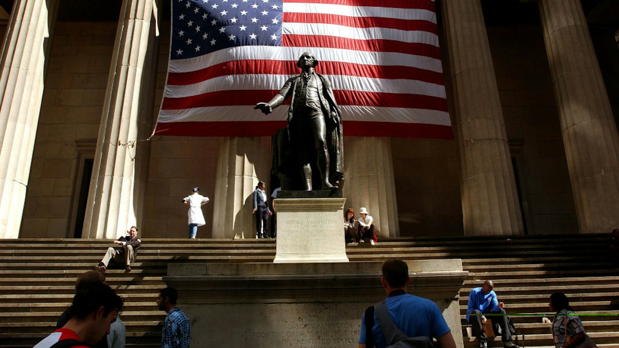 Pedestrians walk around the George Washington statue in front of Federal Hall September 5, 2002 in New York City.
