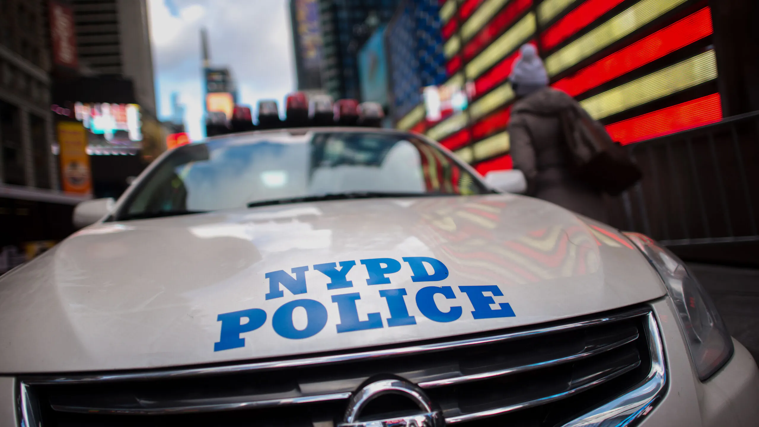 A pedestrians walks past a New York Police Department (NYPD) cruiser on patrol in the Times Square area of New York, U.S., on Monday, Jan. 5, 2015. The New York City Police Department redeployed officers in response to an attack at the Paris offices of a French weekly magazine, in what has become a regular step for the largest U.S. city following terrorist attacks in other parts of the world. Photographer: Craig Warga/Bloomberg via Getty Images