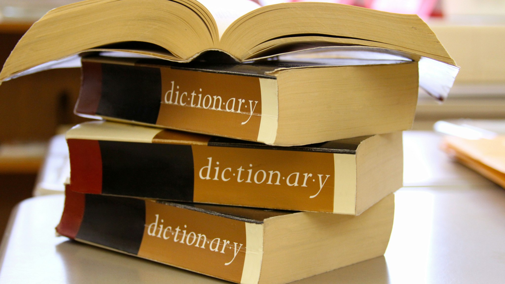 Stack of dictionaries on a desk - stock photo