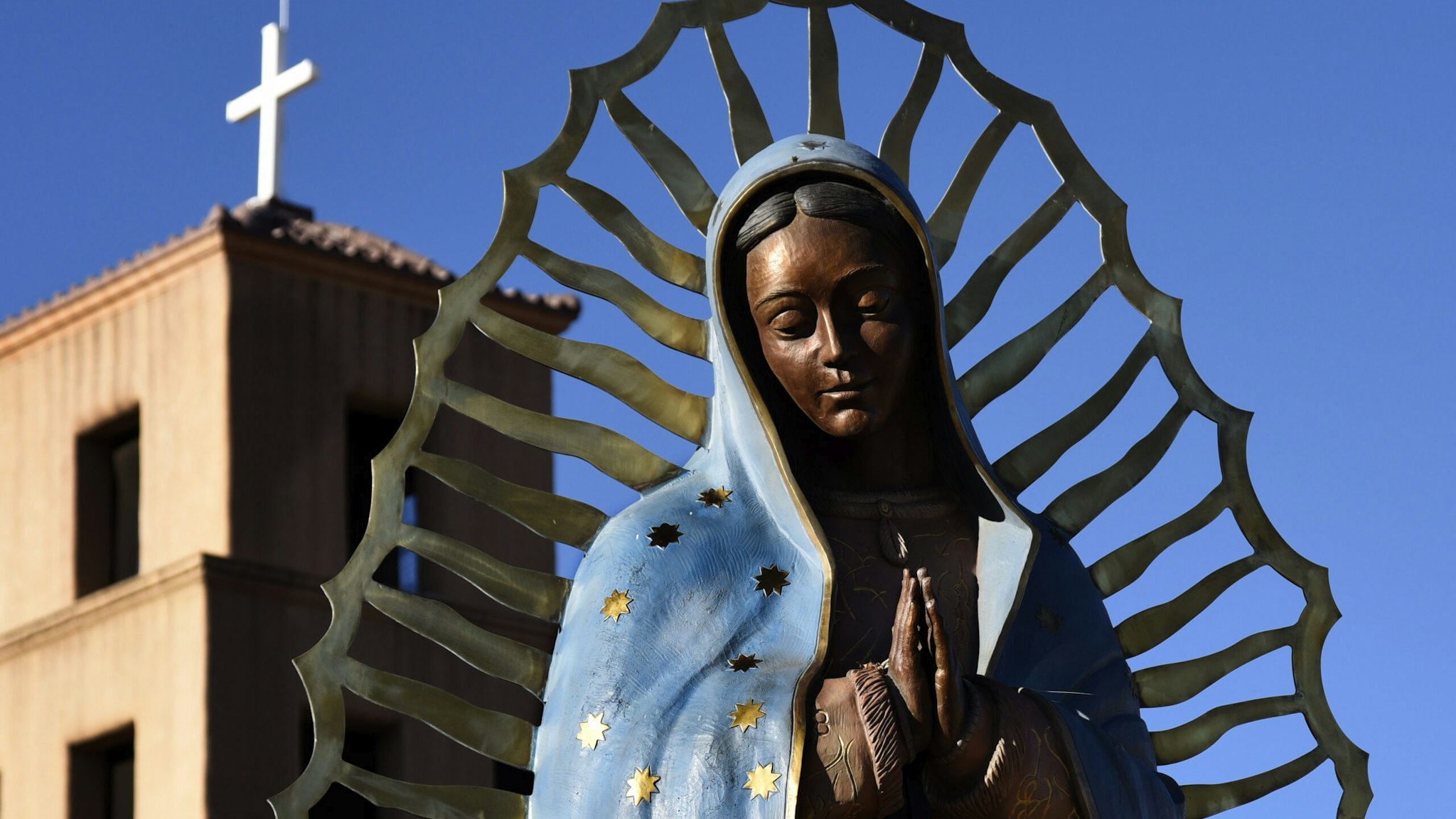 SANTA FE, NM - NOVEMBER 11, 2017: A bronze statue of Our Lady of Guadalupe stands beside the historic Santuario de Guadalupe in Santa Fe, New Mexico. Our Lady of Guadalupe (The Shrine of Our Lady of Guadalupe) was built in the 1770s. It is the oldest standing shrine in the United States. (Photo by Robert Alexander/Getty Images)