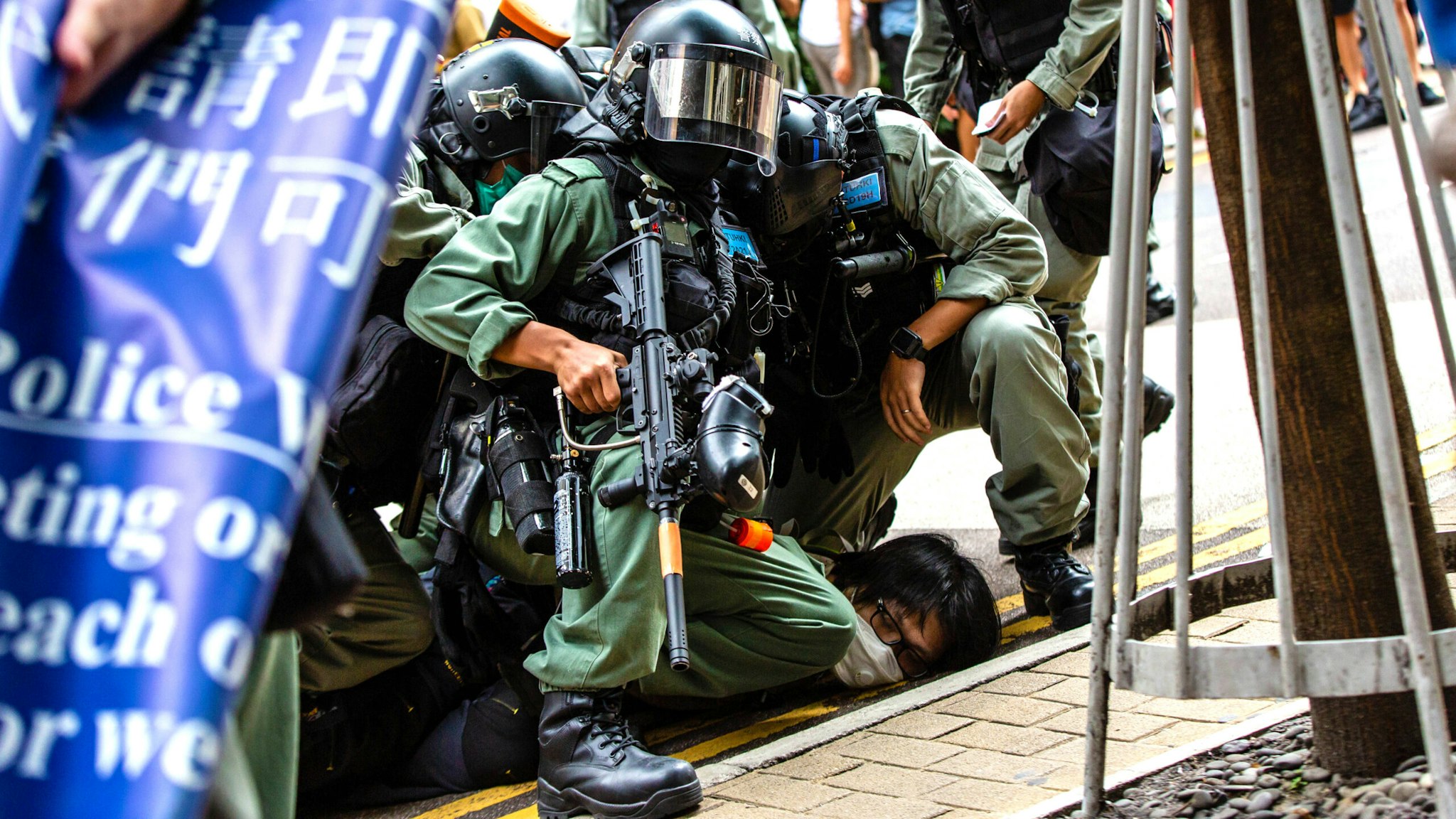 HONG KONG, CHINA - 2020/07/01: Riot police officers pinning down a protester during the demonstration. Following the passing of the National Security Law that would tighten on freedom of expression, Hong Kong protesters marched on the streets to demonstrate. Protesters chanted slogans, sang songs, and obstructed roads. Later, riot police officers arrested several protesters using paintballs and pepper spray.
