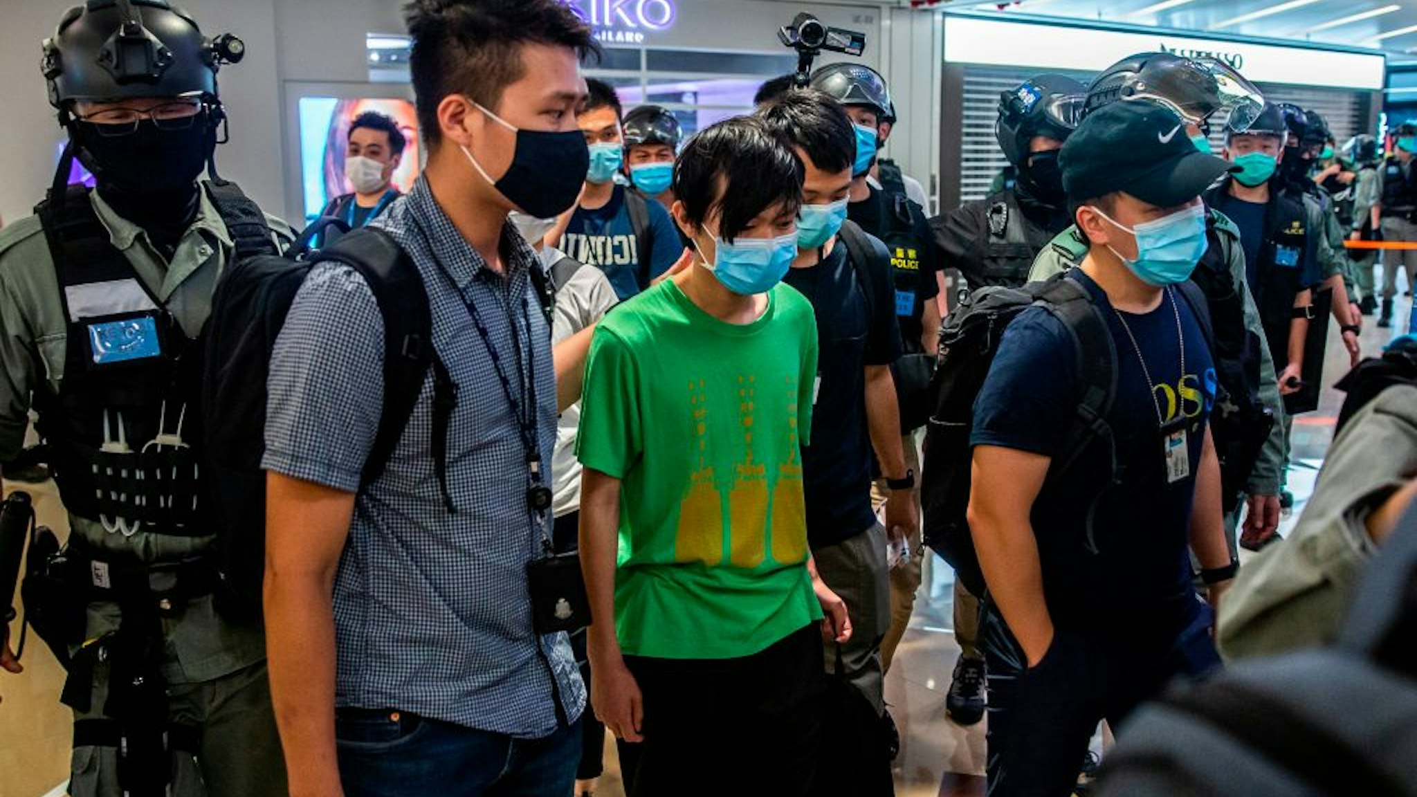 Police take away a man (C) during a demonstration in a mall in Hong Kong on July 6, 2020, in response to a new national security law introduced in the city which makes political views, slogans and signs advocating Hong Kongs independence or liberation illegal. - Hong Kongers are finding creative ways to voice dissent after Beijing blanketed the city in a new security law and police began making arrests for people displaying now forbidden political slogans. (Photo by ISAAC LAWRENCE / AFP) (Photo by ISAAC LAWRENCE/AFP via Getty Images)
