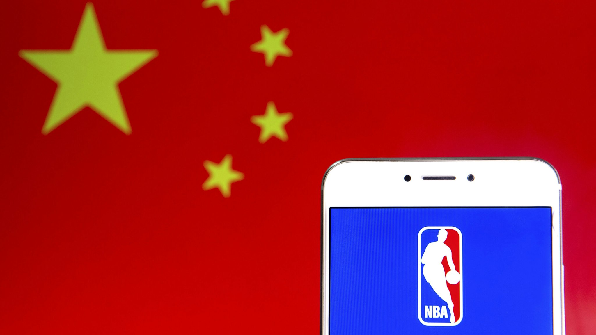 HONG KONG - 2019/04/06: In this photo illustration a American National Basketball Association (NBA) men's professional basketball league logo is seen on an Android mobile device with People's Republic of China flag in the background.