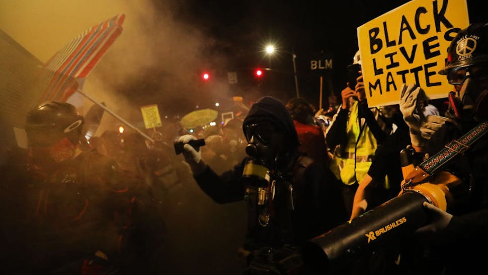 PORTLAND, OREGON - JULY 25: People gather in protest in front of the Mark O. Hatfield federal courthouse in downtown Portland as the city experiences another night of unrest on July 25, 2020 in Portland, Oregon. For over 55 straight nights, protesters in downtown Portland have faced off in often violent clashes with the Portland Police Bureau and, more recently, federal officers. The demonstrations began to honor the life of George Floyd and other black Americans killed by law enforcement and have intensified as the Trump administration called in the federal officers. (Photo by Spencer Platt/Getty Images)