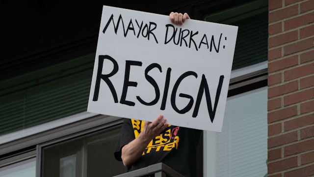 SEATTLE, WA - JUNE 26: A person holds a sign on their balcony as Seattle Mayor Jenny Durkan meets with protesters from the Capitol Hill Organized Protest (CHOP) across the street at First African Methodist Episcopal Church on June 26, 2020 in Seattle, Washington. Earlier in the morning, protesters resisted as city crews attempted to remove barriers at an entrance to CHOP. On Monday, Mayor Durkan said that the city would phase down the CHOP zone and that the Seattle Police Department would return to its vacated East Precinct. (Photo by David Ryder/Getty Images)
