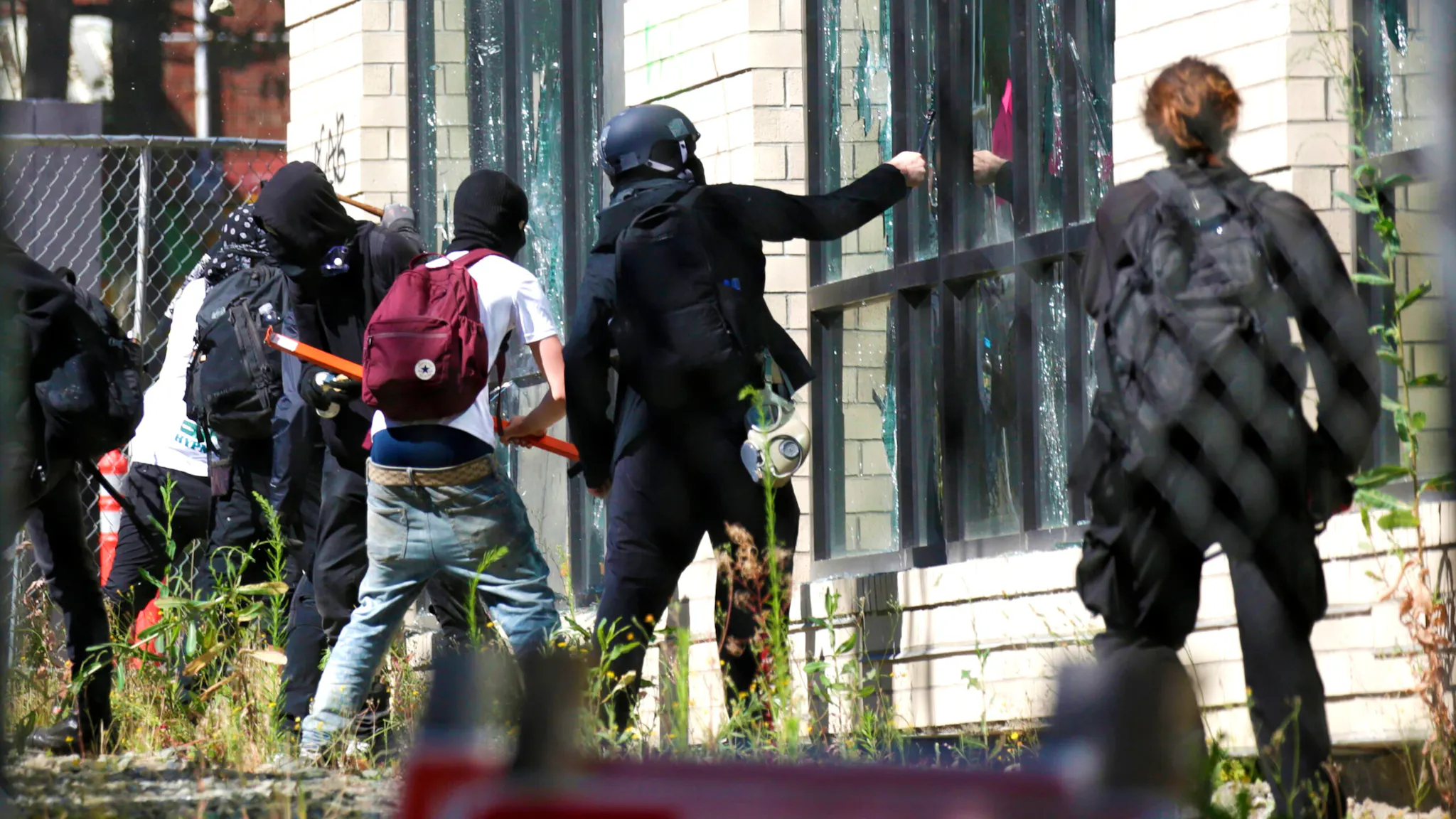 US-POLITICS-PROTEST-UNREST People break windows at the King County Juvenile Detention Center after a group of protesters entered the construction site during demonstrations over Special Response Team presence in Seattle, Washington on July 25, 2020. - Police in Seattle used flashbang grenades and pepper spray Saturday against protesters who set fire to construction trailers outside a youth jail, amid a wave of public anger over President Donald Trump's planned "surge" of federal agents into major cities.
