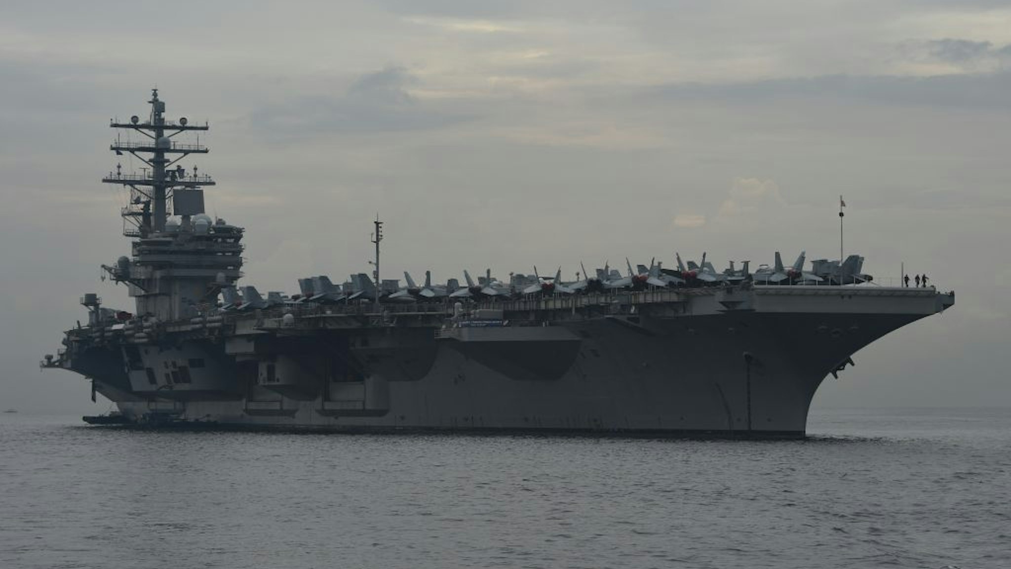This photo taken on June 26, 2018 shows the nuclear-powered aircraft carrier USS Ronald Reagan (CVN-76) anchored off Manila bay. - A US aircraft carrier visited the Philippines on June 26, the third such call in four months, as its commander cited America's "enduring presence" in a region where China's military aims have raised tensions. (Photo by TED ALJIBE / AFP) (Photo credit should read TED ALJIBE/AFP via Getty Images)
