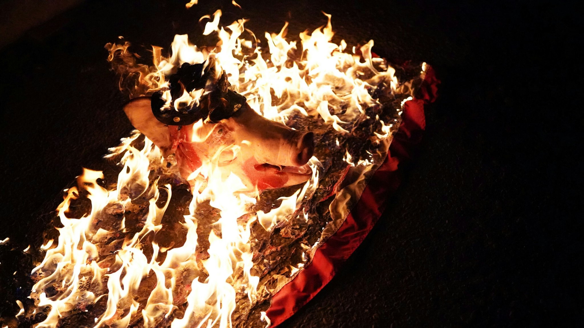 PORTLAND, OR - JULY 30: A pigs head burns during a protest against racial injustice and police brutality in front of the Mark O. Hatfield U.S. Courthouse on July 30, 2020 in Portland, Oregon. Federal officers began a phased withdrawal from the city Thursday, following weeks of violent clashes with protesters.