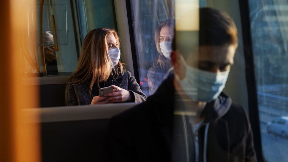Bus riders in masks.