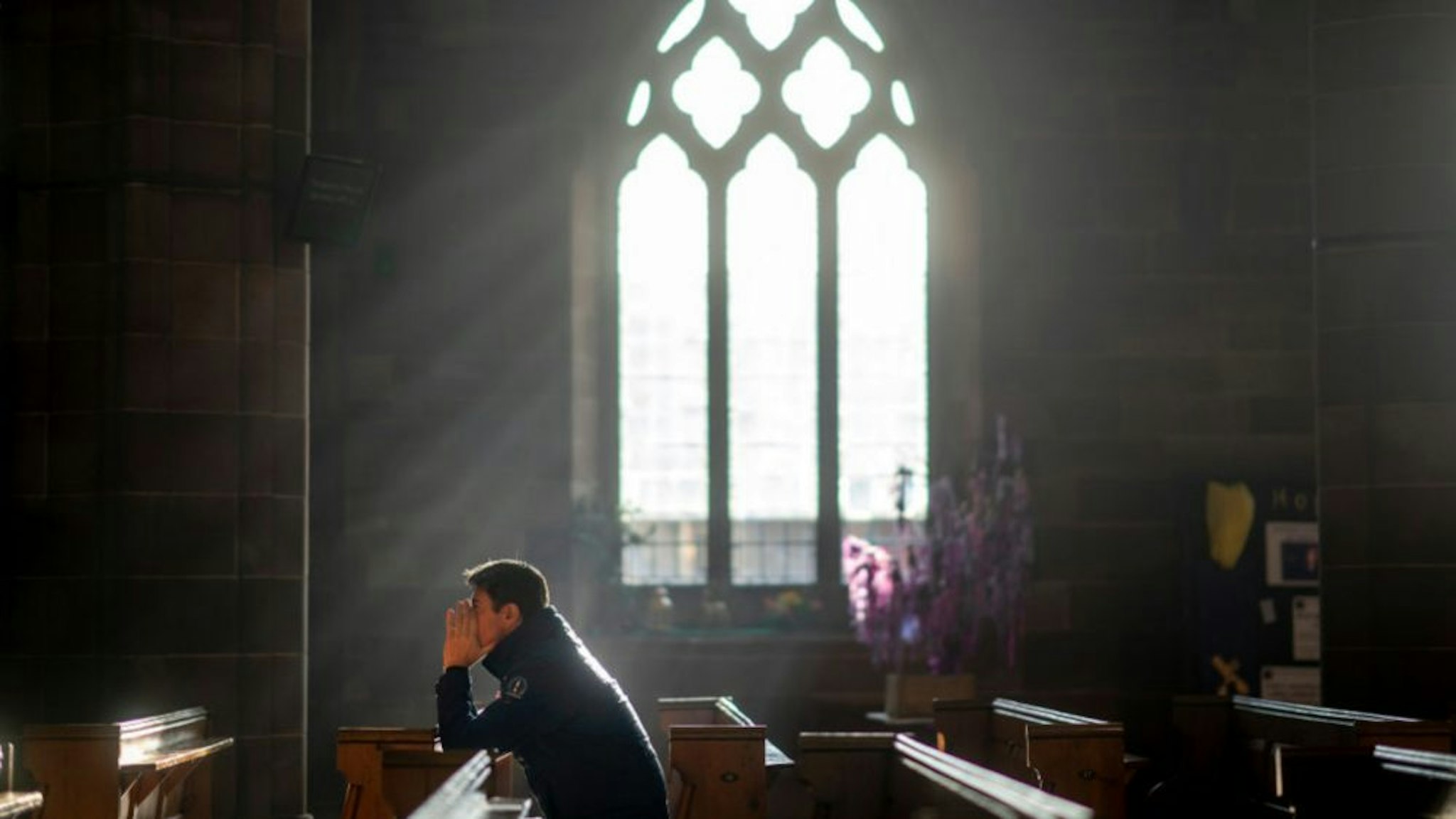 A man prays in a church as shoppers make their last minute purchases on Christmas Eve on December 24, 2018 in Birmingham, England.