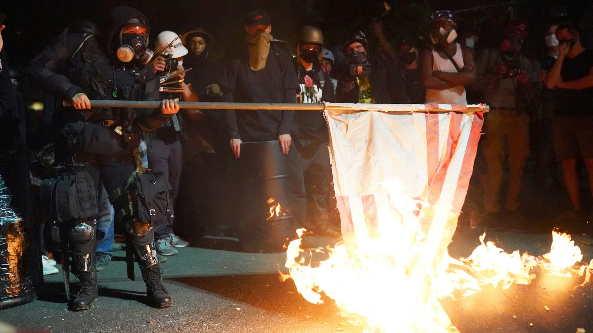 A protester burns an American flag in front of the Mark O. Hatfield U.S. Courthouse in the early morning on August 1, 2020 in Portland, Oregon. Friday was the second night in a row without police intervention, following weeks of clashes between federal officers and protesters in Portland.