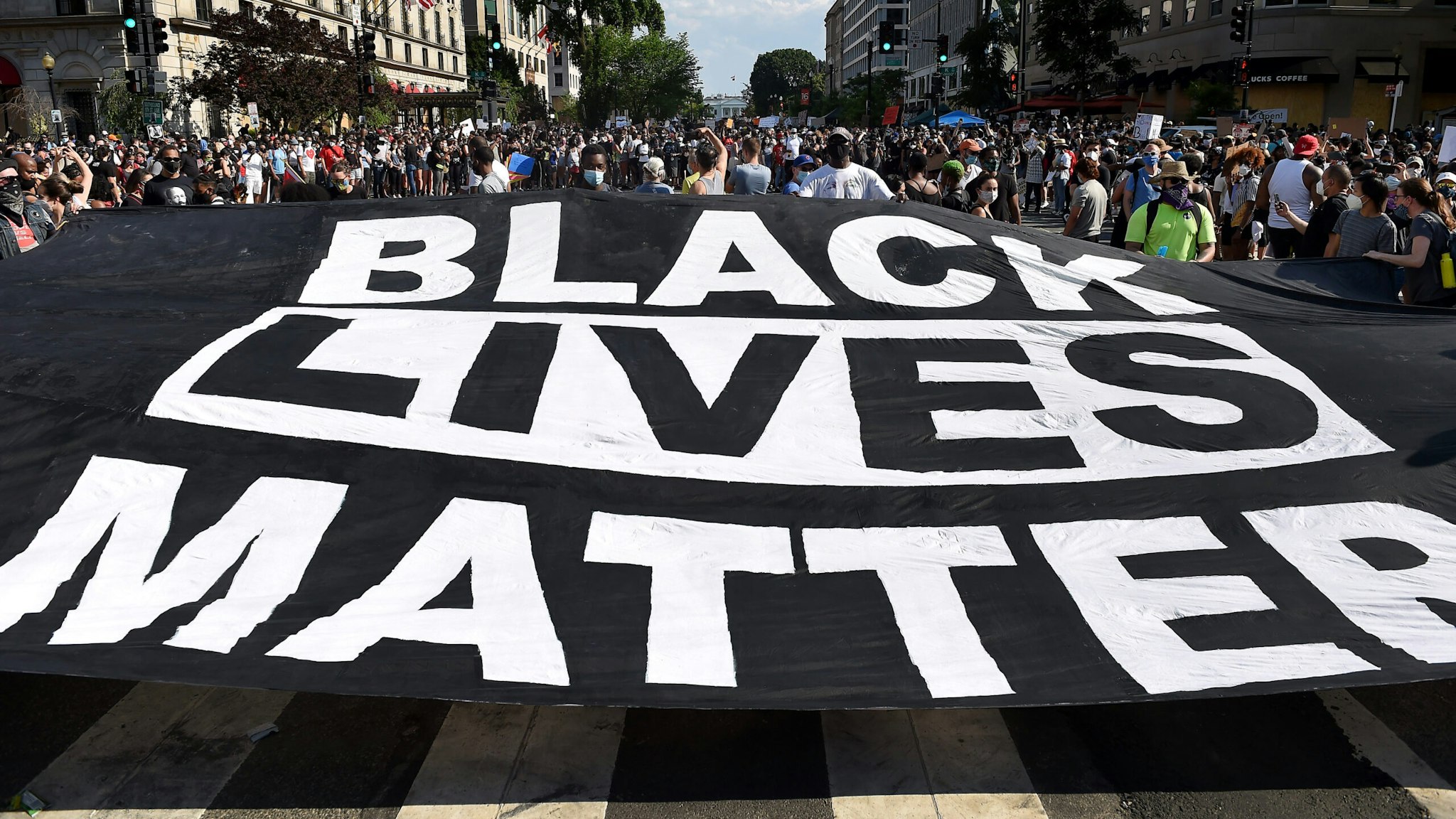 Demonstrators deploy a " Black Lives Matter" banner near the White House during a demonstration against racism and police brutality, in Washington, DC on June 6, 2020. - Demonstrations are being held across the US following the death of George Floyd on May 25, 2020, while being arrested in Minneapolis, Minnesota.