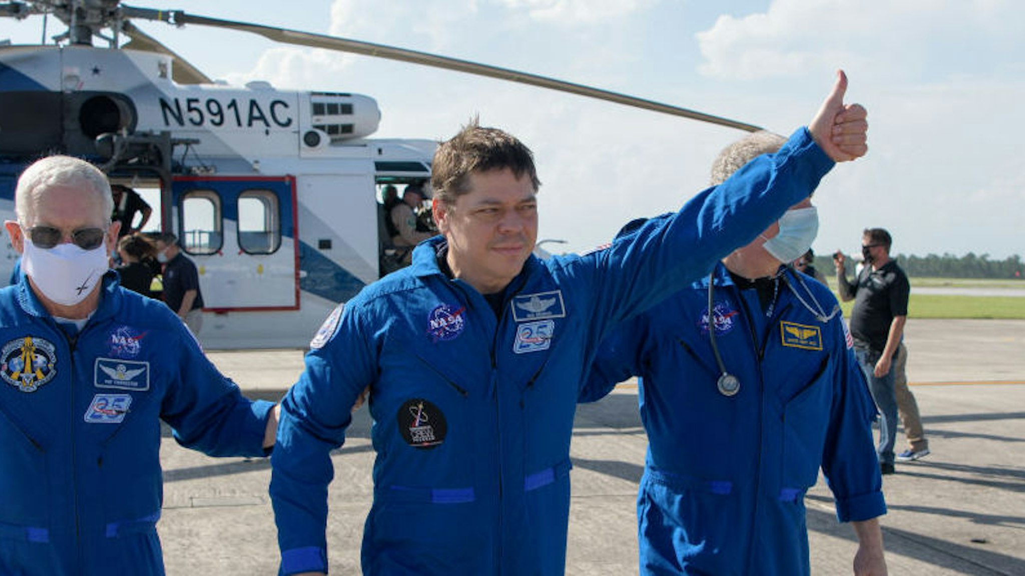 NASA astronaut Robert Behnken gives a thumbs up to onlookers as he boards a plane at Naval Air Station Pensacola to return him and NASA astronaut Douglas Hurley home to Houston a few hours after the duo landed in their SpaceX Crew Dragon Endeavour spacecraft off the coast of Pensacola, Florida, Sunday, Aug. 2, 2020. The Demo-2 test flight for NASA's Commercial Crew Program was the first to deliver astronauts to the International Space Station and return them safely to Earth onboard a commercially built and operated spacecraft. Behnken and Hurley returned after spending 64 days in space.