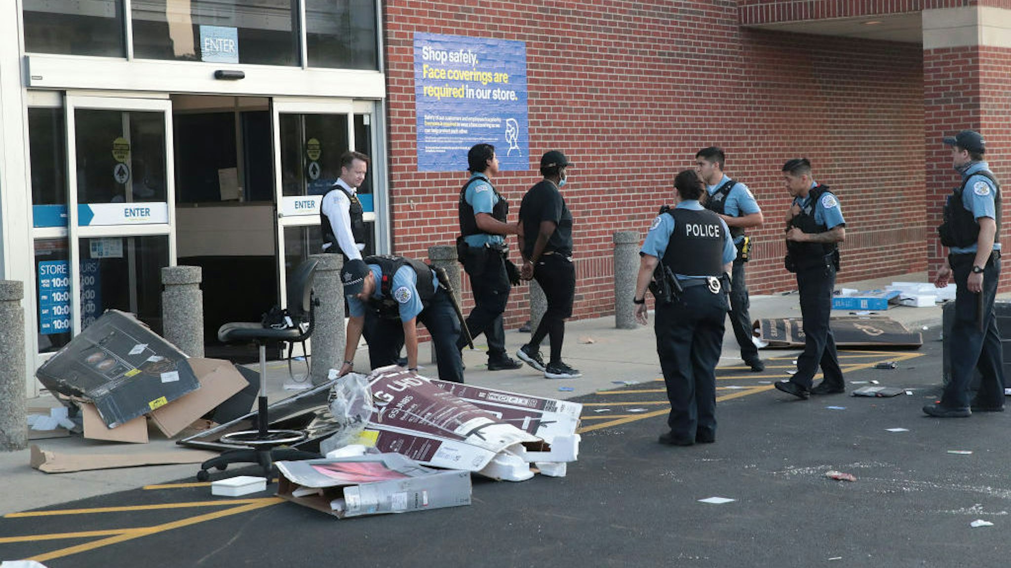 CHICAGO, ILLINOIS - AUGUST 10: Police officers detain a man who was found inside of a Best Buy store after parts of the city had widespread looting and vandalism, on August 10, 2020 in Chicago, Illinois. Police made several arrests during the night of unrest and recovered at least one firearm. (Photo by Scott Olson/Getty Images)