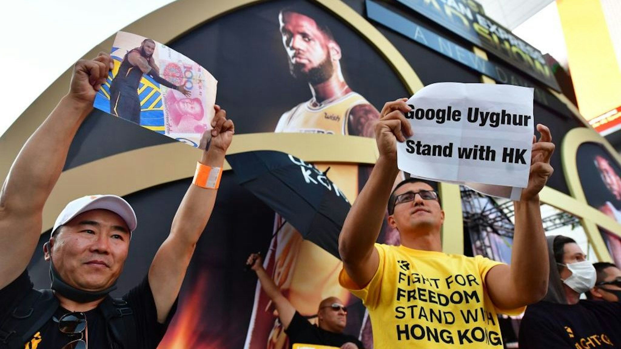 Anti-Chinese Communist Party activists protest outside Staples Center ahead of the Lakers vs Clippers NBA season opener in Los Angeles on October 22, 2019. - Activists handed out free T-shirts displaying support for the Hong Kong protests after an NBA fan in Northern California raised enough money to pay for more than 10,000 shirts, according to the organizer who goes by the pseudonym "Sun Lared" as LeBron James of the Lakers suffers the brunt of people's anger after comments he made in response to the tweet from Houston Rockets GM Daryl Morey in support of Hong Kong protesters, and drawing the ire of the Chinese Communist Party. (Photo by Frederic J. BROWN / AFP)