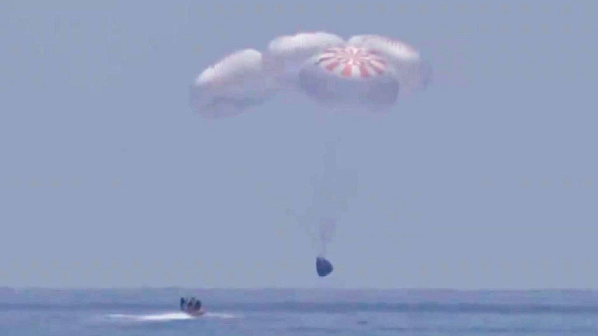 GULF OF MEXICO - AUGUST 2: In this screen grab from NASA TV, SpaceX 's Crew Dragon capsule spacecraft just before it splashes down in to the water after completing NASA's SpaceX Demo-2 mission to the International Space Station with NASA astronauts Robert Behnken and Douglas Hurley onboard, August 2, 2020 off the coast of Pensacola, Florida in the Gulf of Mexico. The Demo-2 mission is the first launch with astronauts of the SpaceX Crew Dragon spacecraft and Falcon 9 rocket to the International Space Station as part of the agency's Commercial Crew Program. The test flight serves as an end-to-end demonstration of SpaceXs crew transportation system. Behnken and Hurley launched at 3:22 p.m. EDT on Saturday, May 30, from Launch Complex 39A at the Kennedy Space Center. A new era of human spaceflight is set to begin as American astronauts once again launch on an American rocket from American soil to low-Earth orbit for the first time since the conclusion of the Space Shuttle Program in 2011