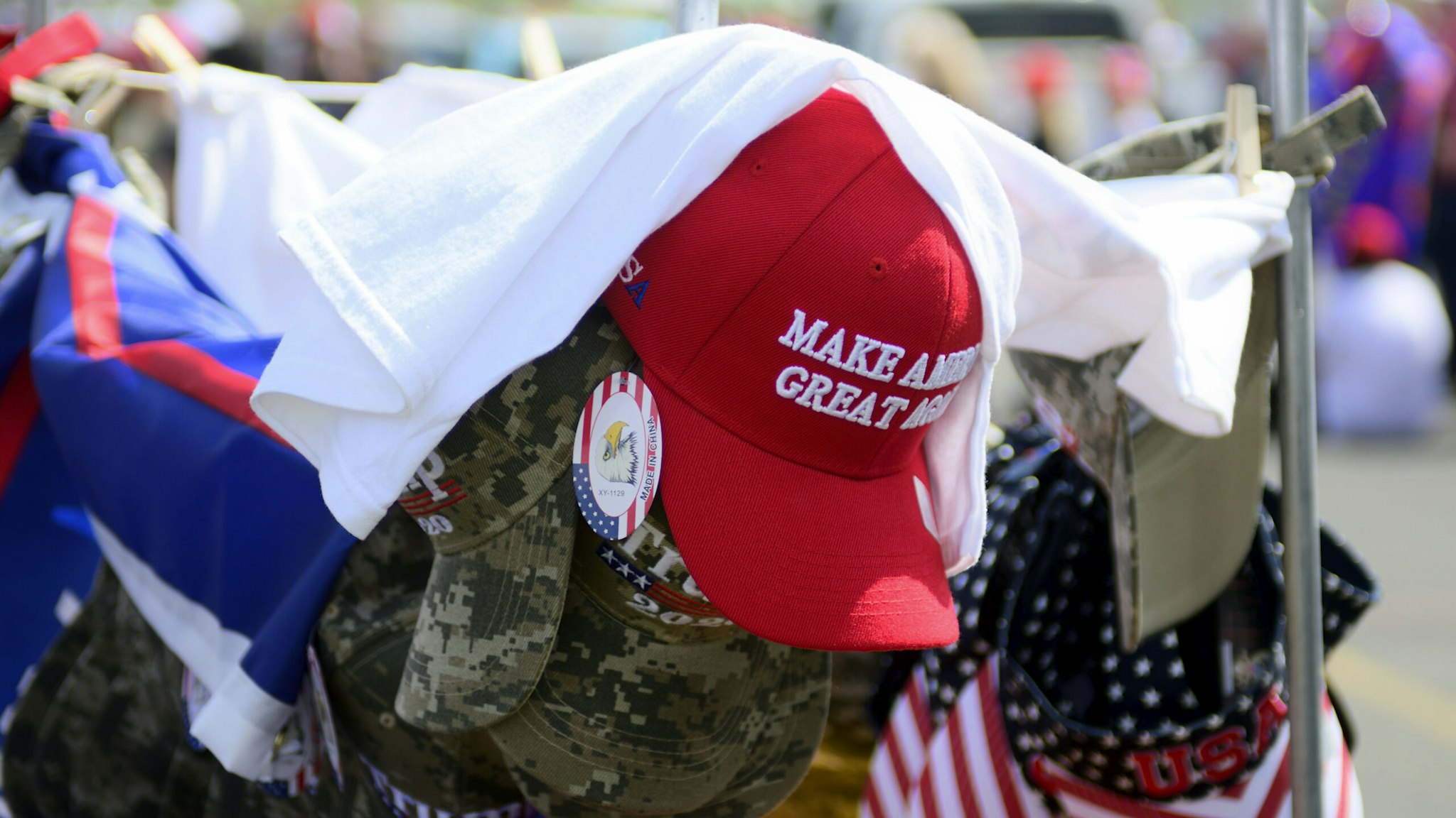A red Make America Great Again hat sits atop of a rack with camouflage and patriotic hats as supporters wait in line hours ahead of a Trump campaign rally at the Williamsport Regional Airport, in Montoursville, PA on May 20, 2019. (Photo by Bastiaan Slabbers/NurPhoto via Getty Images)