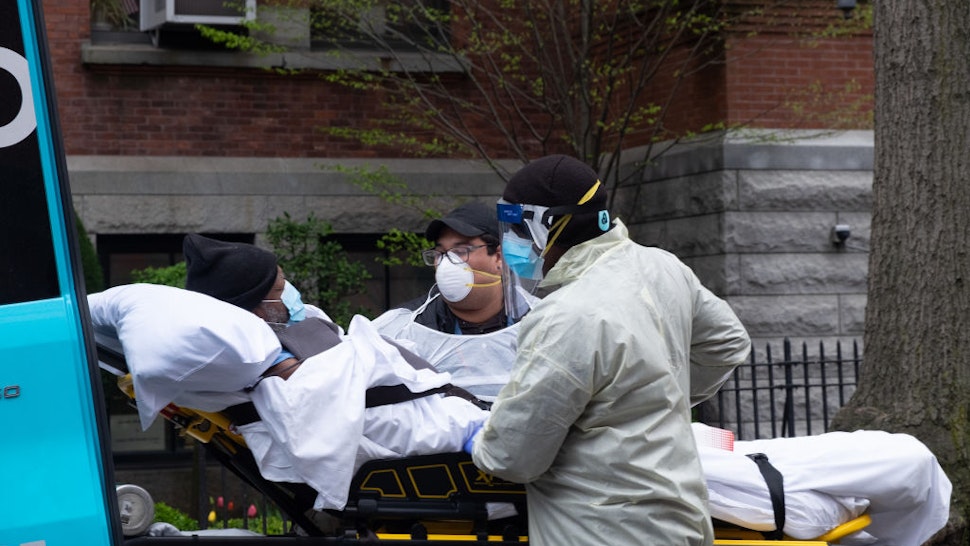 Ambulance workers pickup an elderly man from Cobble Hill Health Center, the nursing home that recently registered an alarming amount of covid-19 deaths.