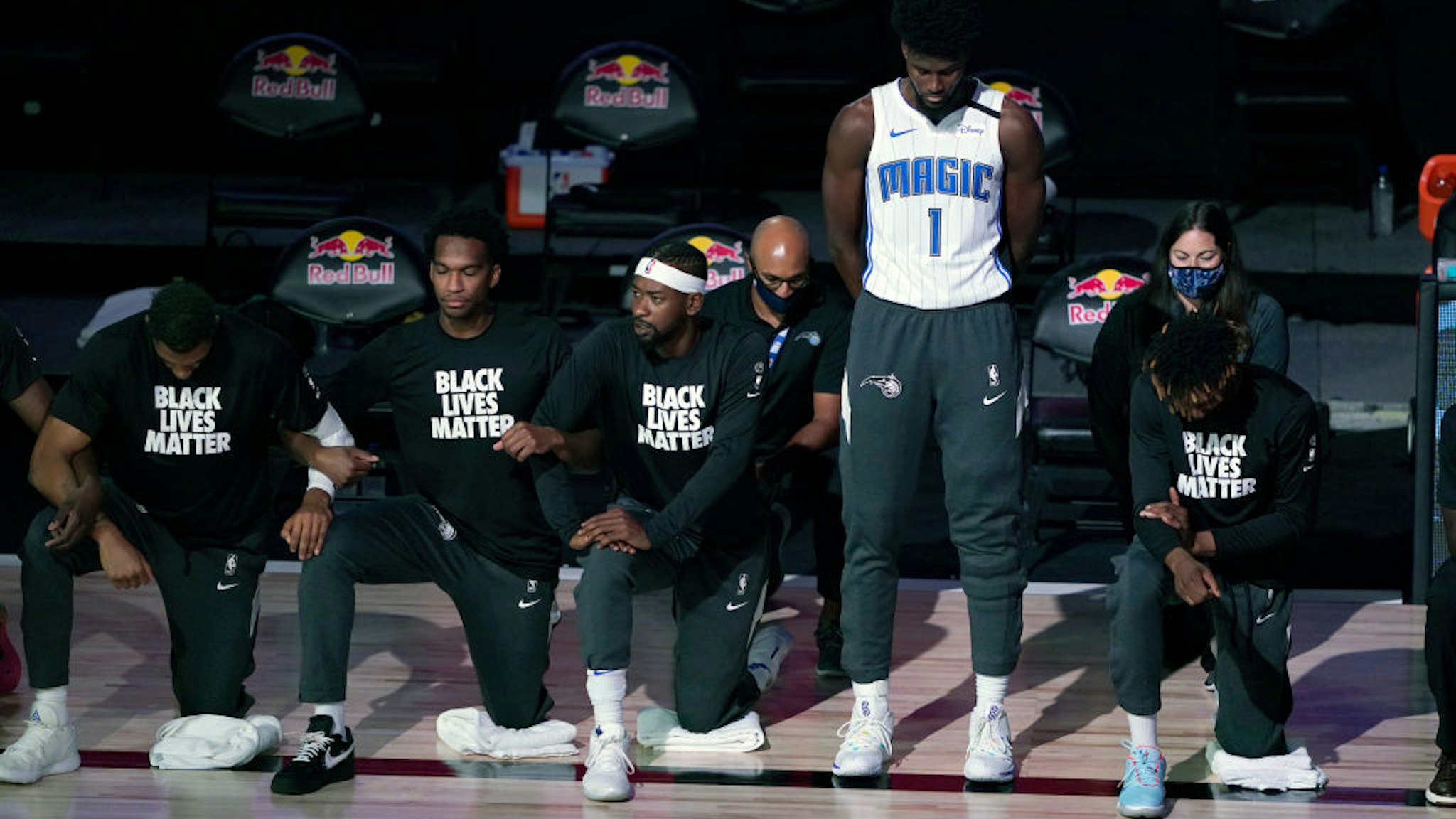 Jonathan Isaac #1 of the Orlando Magic stands as others kneel before the start of a game between the Brooklyn Nets and the Orlando Magic on July 31, 2020