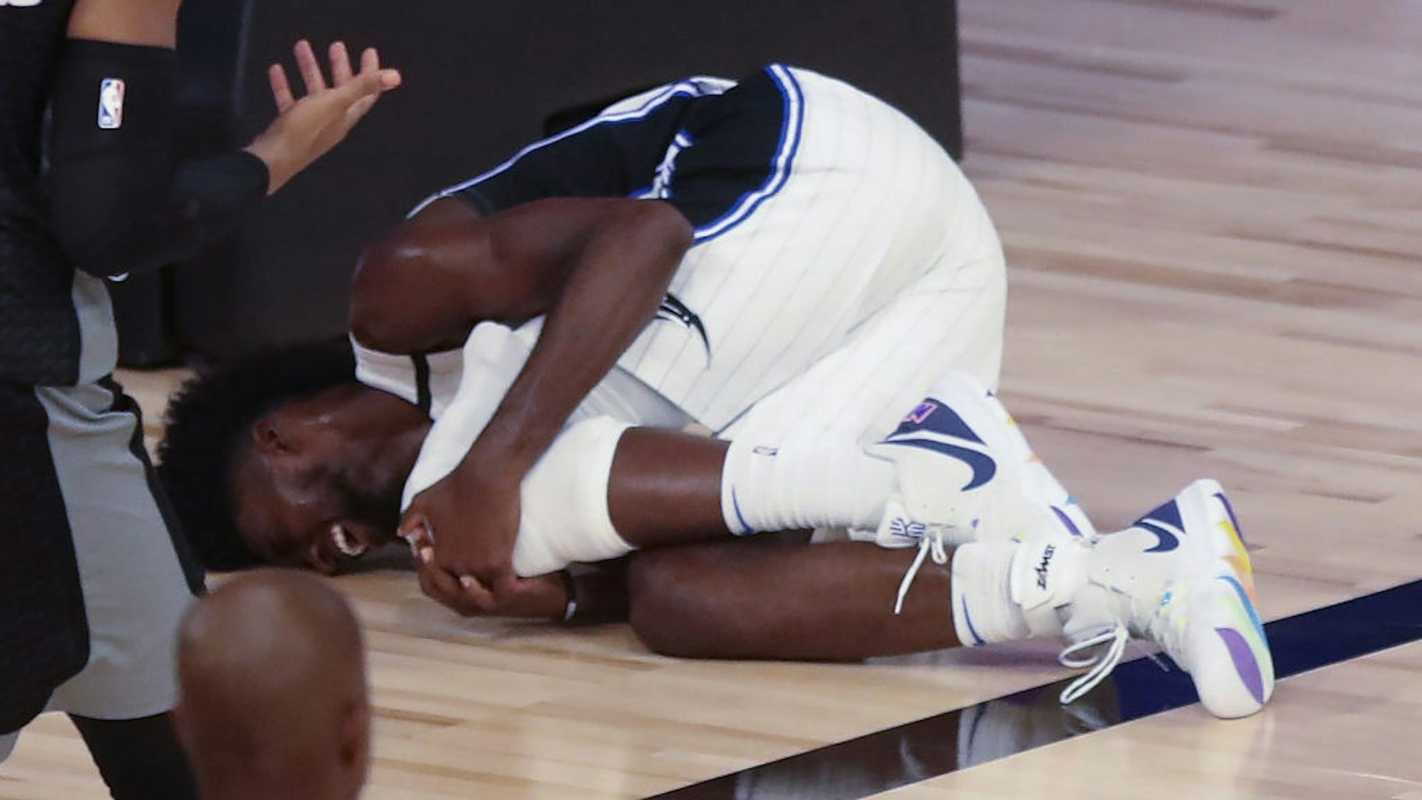 Orlando Magic forward Jonathan Isaac lays on the court holding his left knee after falling during a play in the fourth quarter against the Sacramento Kings on Sunday, Aug. 2, 2020 at Disney's Wide World of Sports' HP Field House in Lake Buena Vista, Florida.