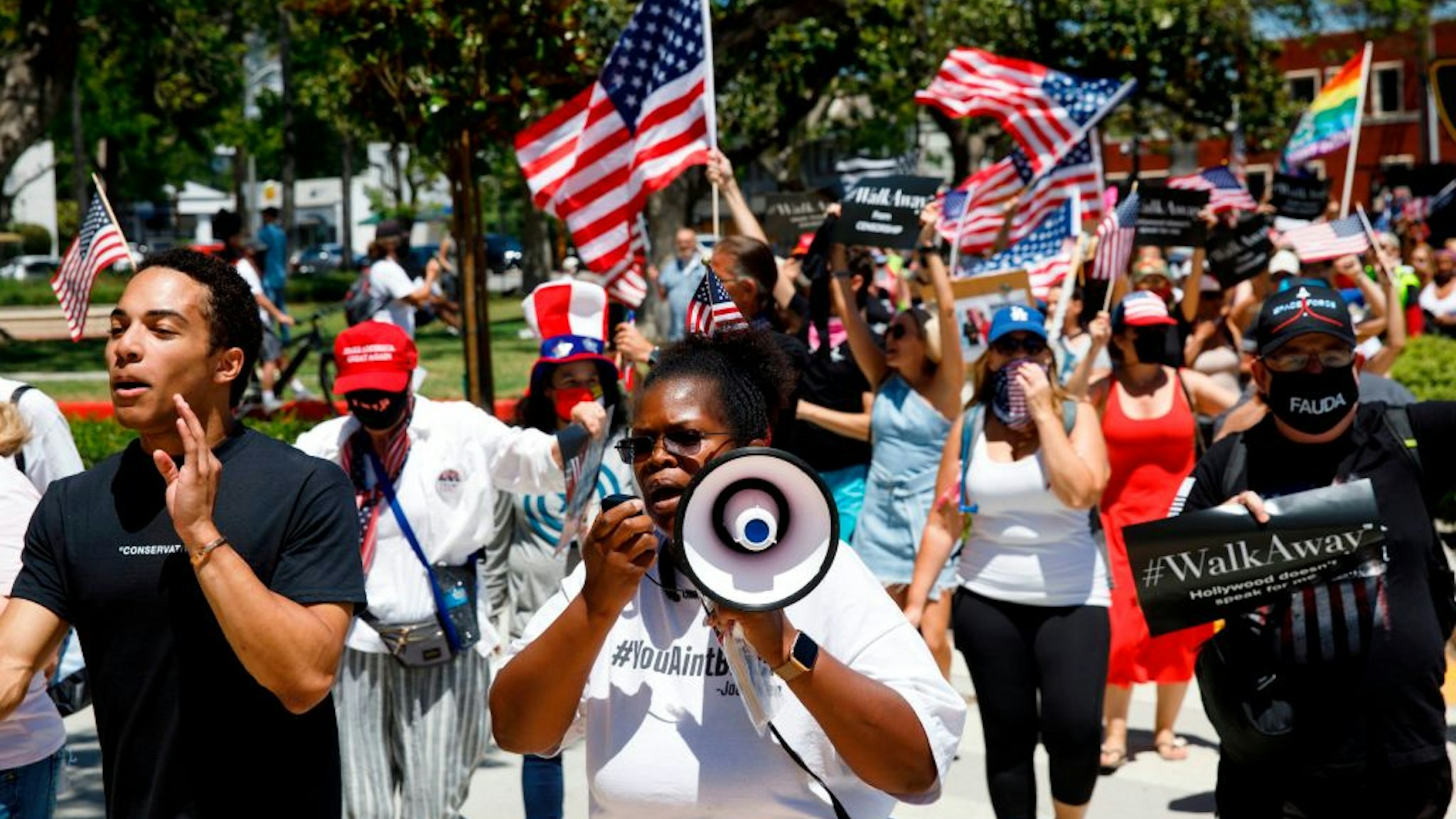 Demonstrators wave flags as they march in support of the US president during a WalkAway rally on August 8, 2020 in Beverly Hills, California.