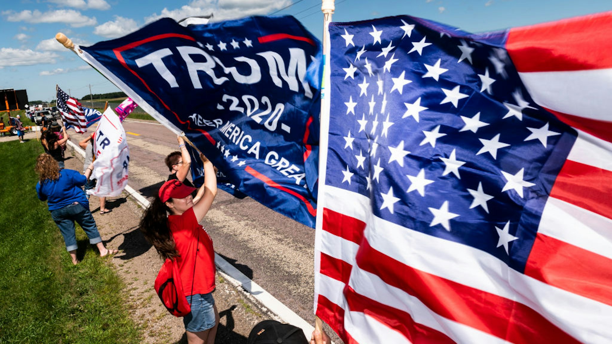 Supporters wave flags outside of Mankato Regional Airport as President Donald Trump makes a campaign stop on August 17, 2020 in Mankato, Minnesota.