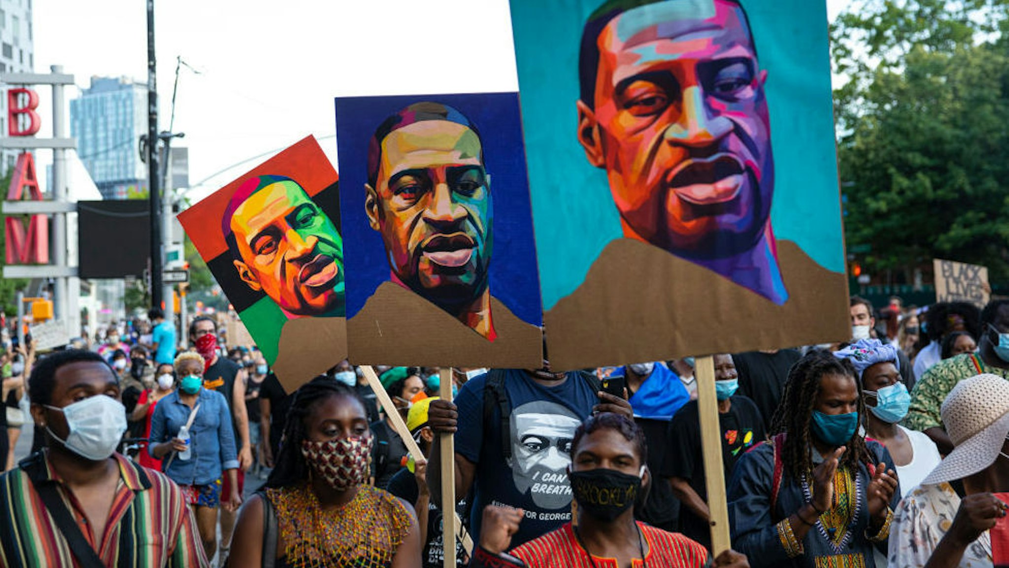 Pedestrians carry posters with the picture of George Floyd who was killed in police custody three weeks earlier in Minneapolis, Minnesota during the Juneteenth protest march on June 19, 2020 in the Brooklyn borough of New York City.