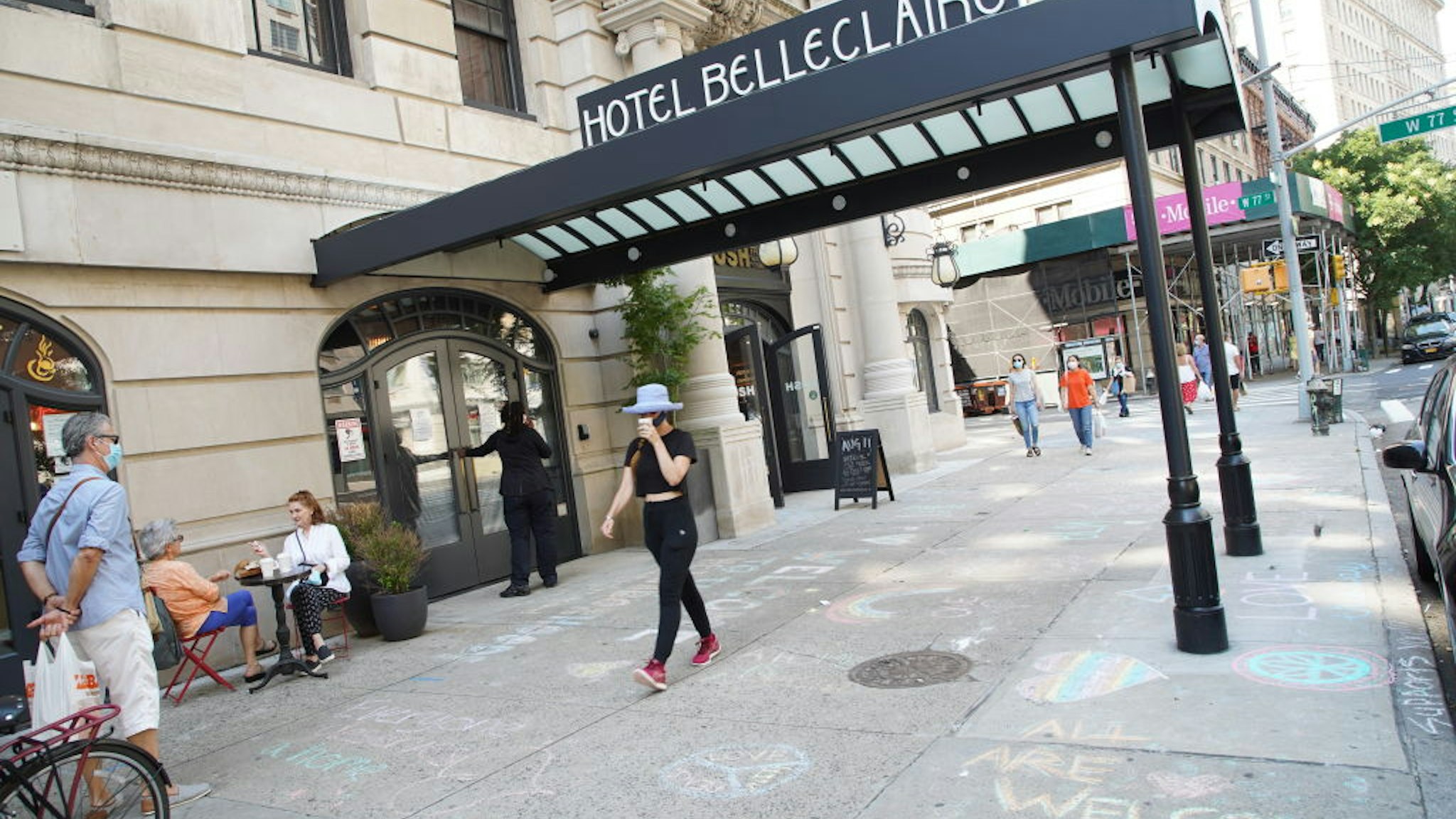 "All are welcome" is written in chalk on the pavement at Hotel Belleclaire on the Upper West Side of Manhattan