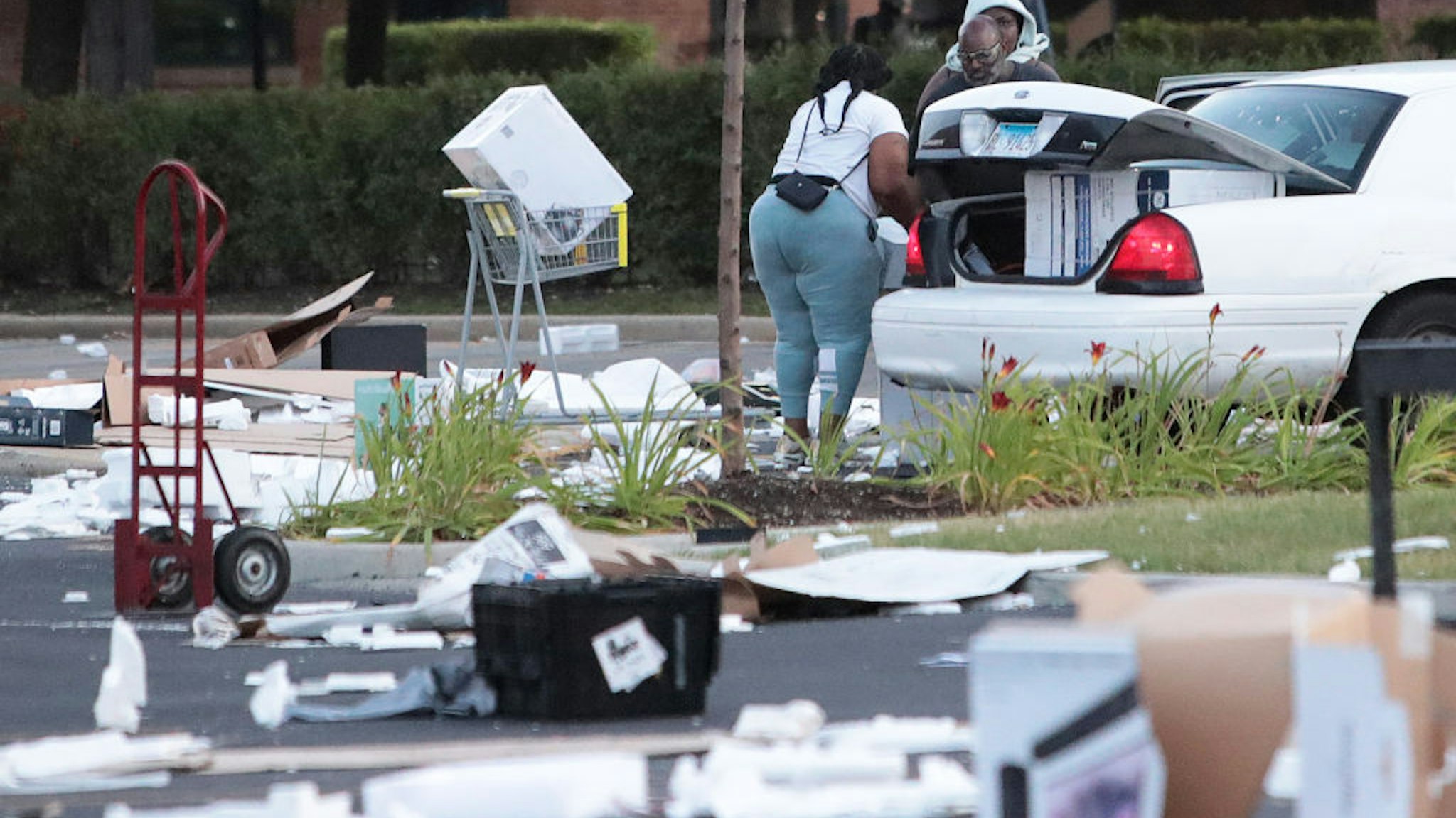 People load merchandise into a car near a looted Best Buy store after parts of the city had widespread looting and vandalism, on August 10, 2020 in Chicago, Illinois.
