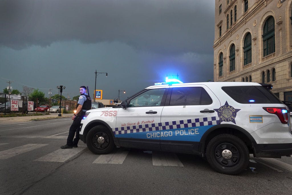 CHICAGO, ILLINOIS - AUGUST 10: A police officer stands guard following unrest on the city's westside moments before a derecho storm hits the area on August 10, 2020 in Chicago, Illinois. The storm, with winds gusts close to 100 miles per hour, downed trees and power lines as it moved through the city and suburbs. (Photo by Scott Olson/Getty Images)