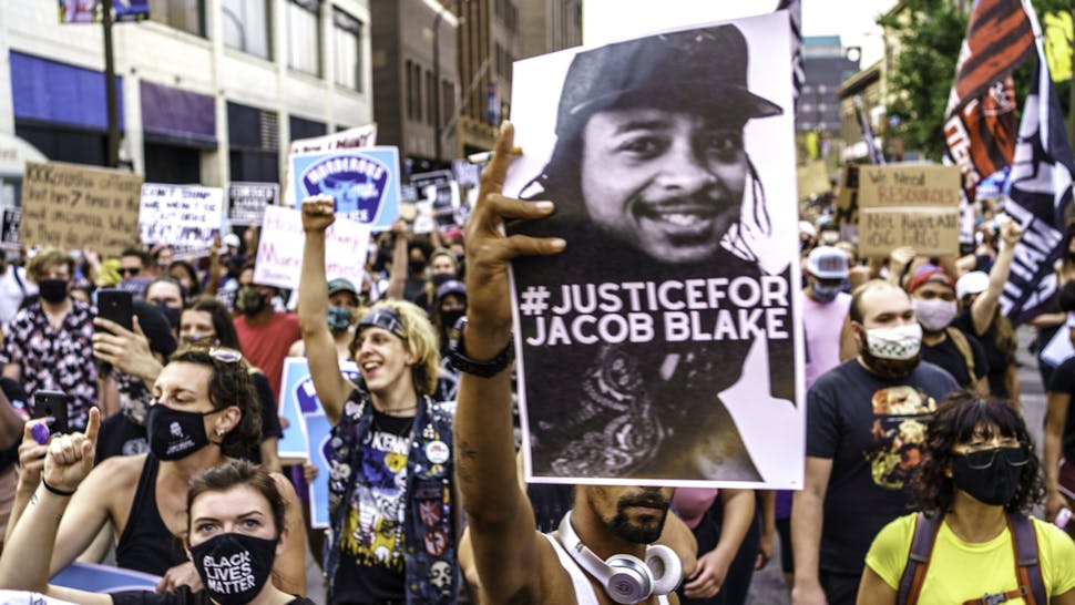 TOPSHOT - Protesters march near the Minneapolis 1st Police precinct during a demonstration against police brutality and racism on August 24, 2020 in Minneapolis, Minnesota. - It was the second day of demonstrations in Kenosha after video circulated Sunday showing the shooting of Jacob Blake -- multiple times, in the back, as he tried to get in his car, with his three children watching.