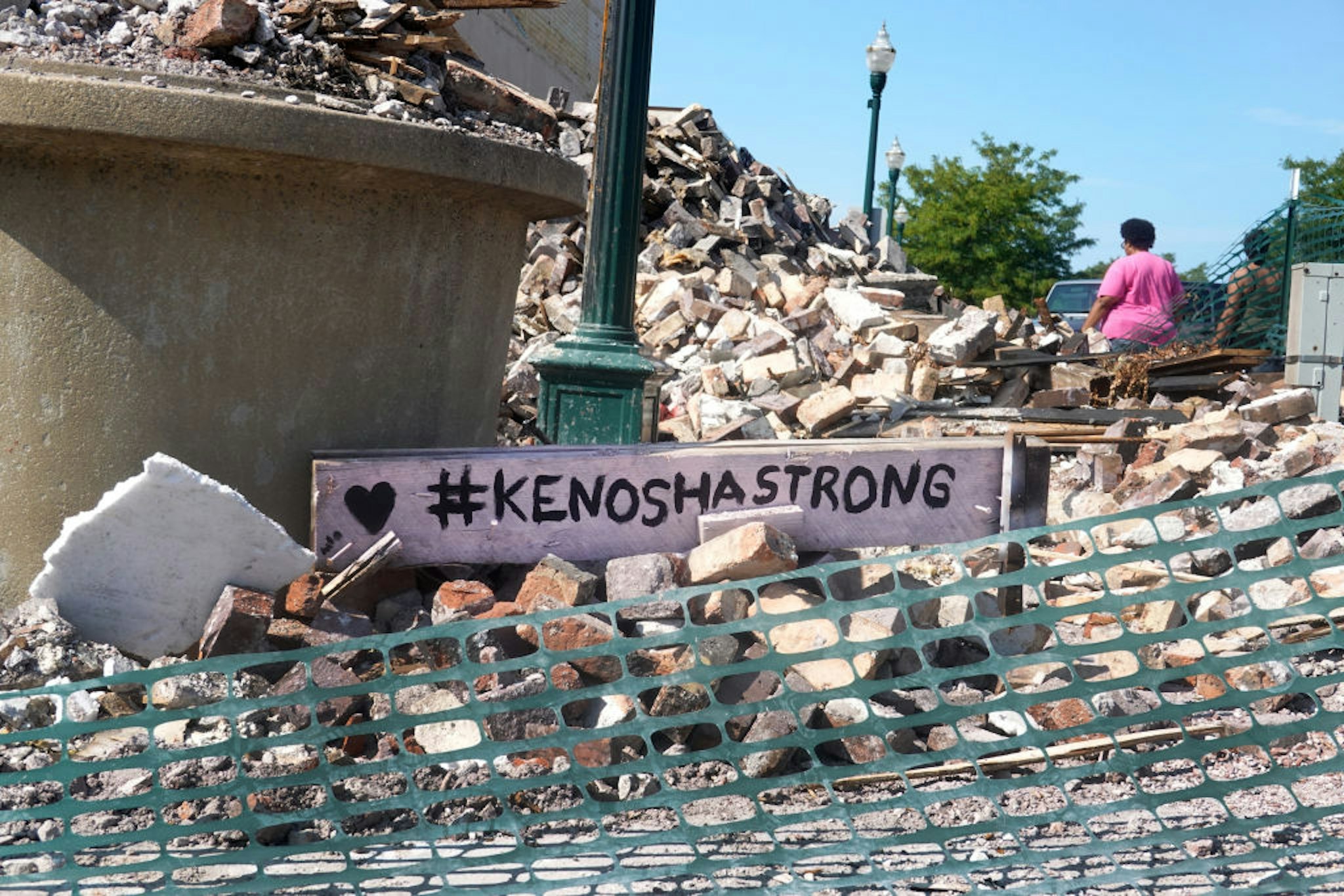 KENOSHA, WISCONSIN - AUGUST 28: People walk past a building that was reduced to rubble after being burned during recent rioting following the shooting of Jacob Blake on August 28, 2020 in Kenosha, Wisconsin. Blake remains in the hospital after being shot seven times in the back in front of his three children by a police officer.