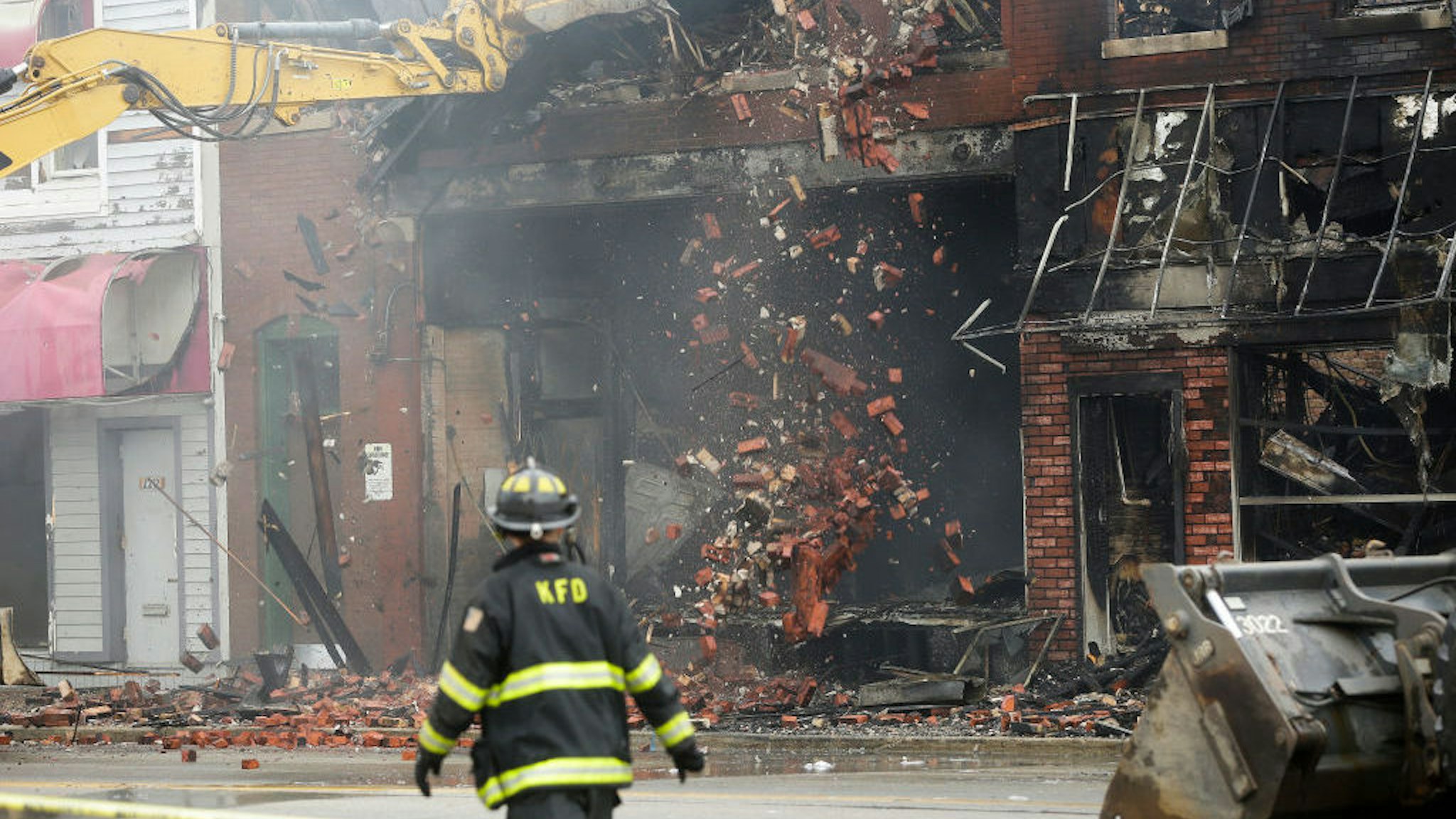 A firefighter watches as a business destroyed by a fire is demolished after protesters set fires to business during overnight riots on Tuesday, August 25, 2020 in Kenosha, Wisconsin. Demonstrators are protesting the police shooting of JacobBlake, who was shot in the back multiple times by police officers responding to a domestic dispute call Sunday. Photo by Joshua Lott for The Washington Post via Getty Images