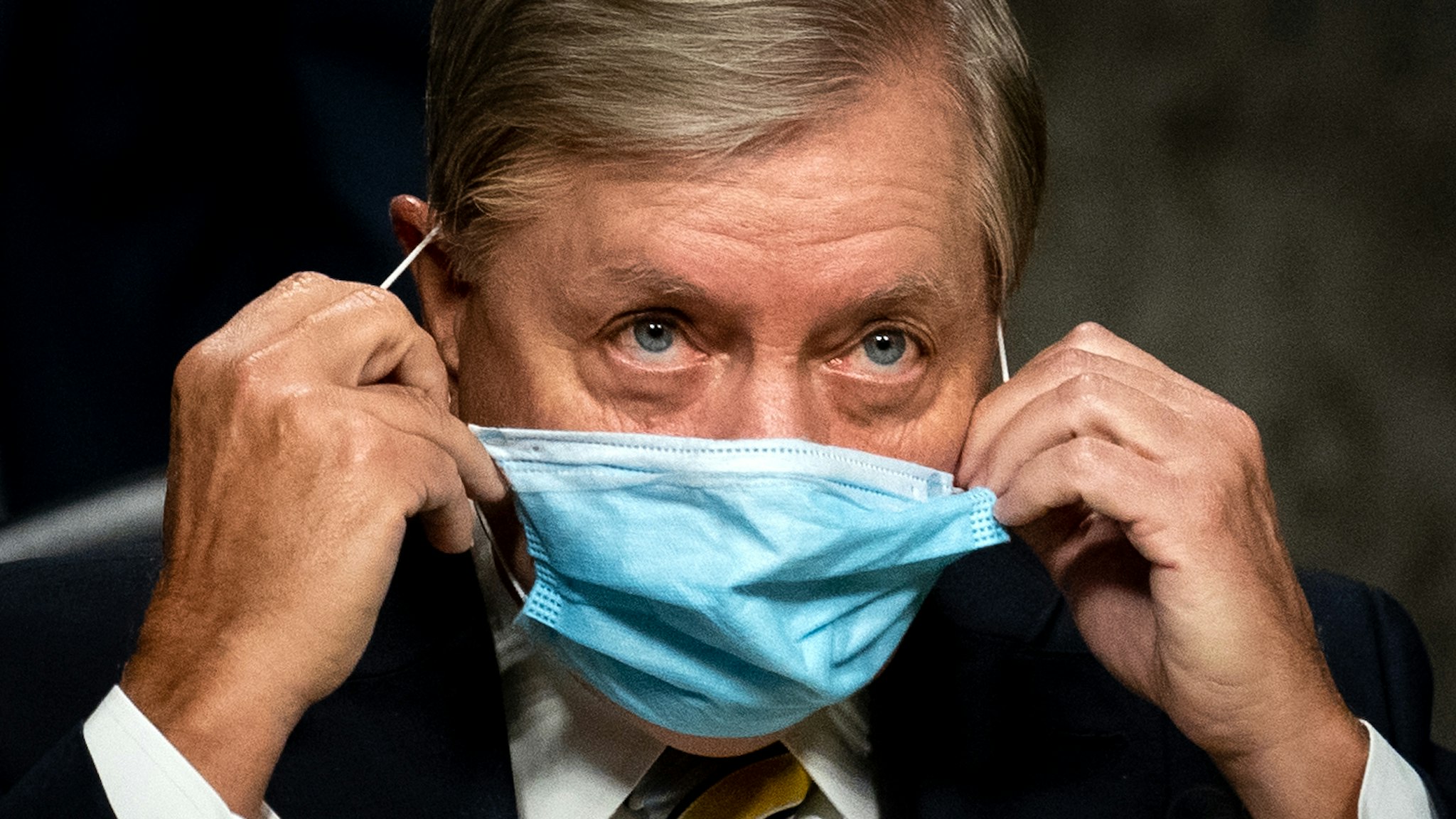 WASHINGTON, DC - AUGUST 05: Committee Chairman Sen. Lindsey Graham (R-SC) removes his face mask before the start a Senate Judiciary Committee hearing on "Oversight of the Crossfire Hurricane Investigation" on Capitol Hill on August 5, 2020 in Washington, DC. Crossfire Hurricane was an FBI counterintelligence investigation relating to contacts between Russian officials and associates of Donald Trump.