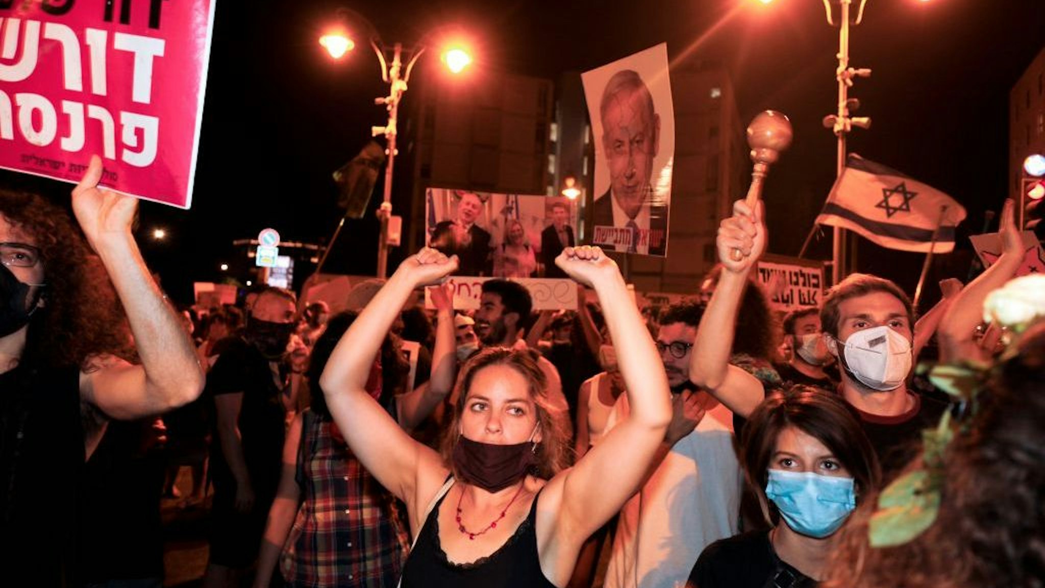 Protesters chant slogans during a demonstration of thousands against the Israeli government near the Prime Minister's residence in Jerusalem on August 2, 2020. - Thousands protested against Prime Minister Benjamin Netanyahu across Israel on Saturday night, demanding he resign over alleged corruption and a resurgence of coronavirus cases. (Photo by MENAHEM KAHANA / AFP)
