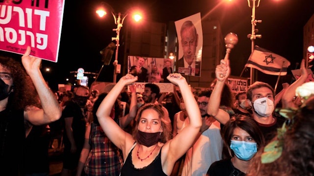 Protesters chant slogans during a demonstration of thousands against the Israeli government near the Prime Minister's residence in Jerusalem on August 2, 2020. - Thousands protested against Prime Minister Benjamin Netanyahu across Israel on Saturday night, demanding he resign over alleged corruption and a resurgence of coronavirus cases. (Photo by MENAHEM KAHANA / AFP)