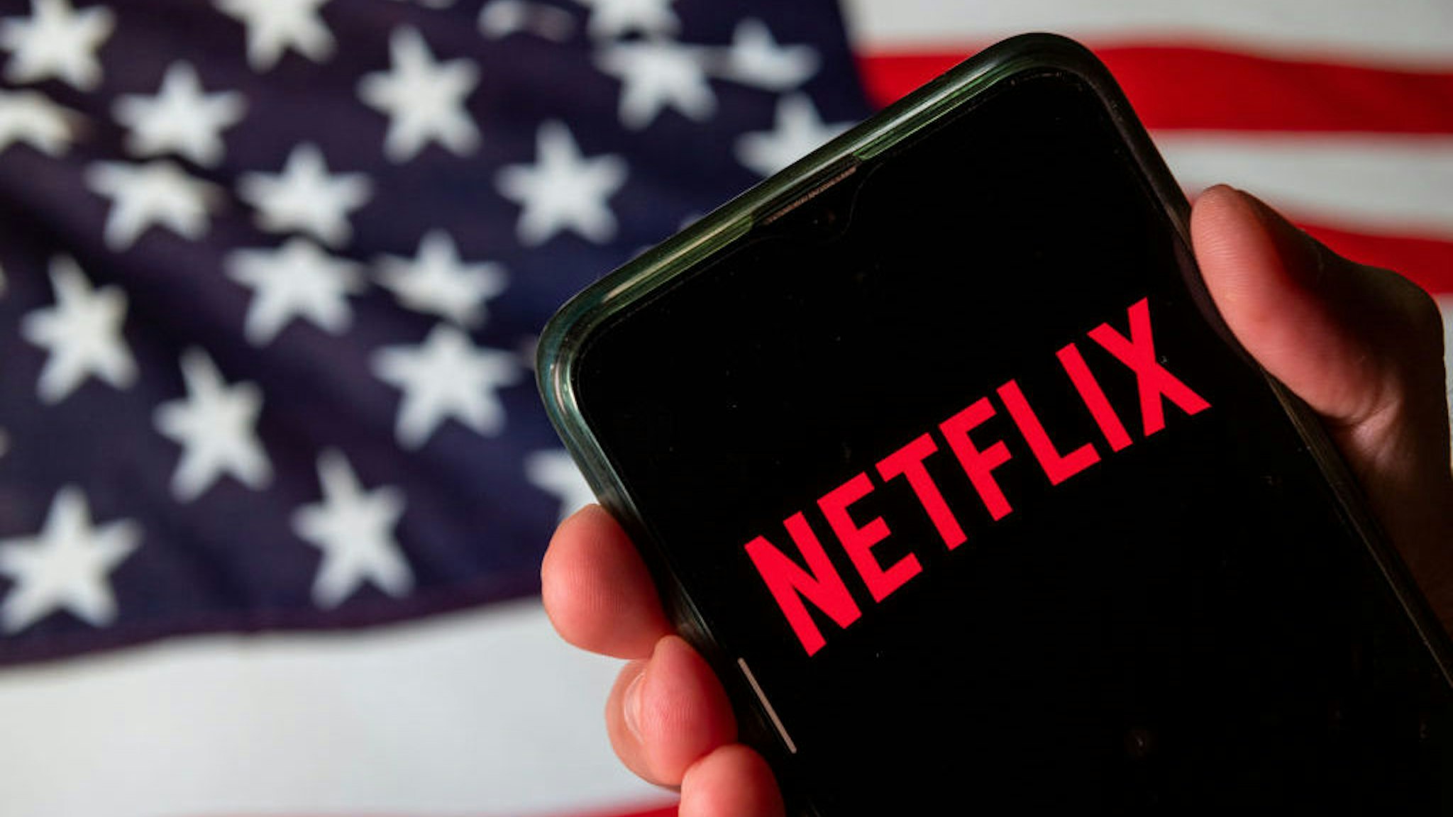 In this photo illustration the American global on-demand Internet streaming media provider Netflix logo is seen on an Android mobile device with United States of America flag in the background. (Photo Illustration by Budrul Chukrut/SOPA Images/LightRocket via Getty Images)