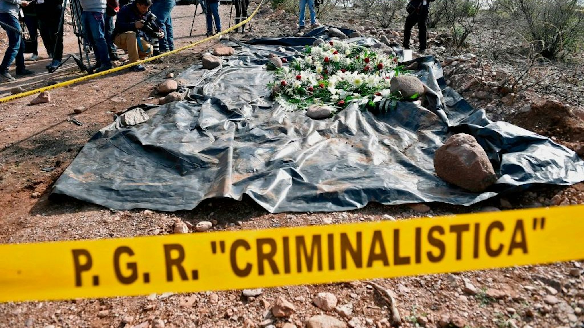 The press surrounds the site where nine Mormon women and children were murdered past November in an ambush, in Galeana, Chihuahua state, Mexico, on January 12, 2020. - Mexican President Andres Manuel Lopez Obrador is in Bavispe to meet with relatives of the nine Mormon victims of the November 4 attack, which happened on an isolated dirt road in a region known for turf wars between drug cartels fighting over lucrative trafficking routes to the United States. (Photo by ALFREDO ESTRELLA / AFP)