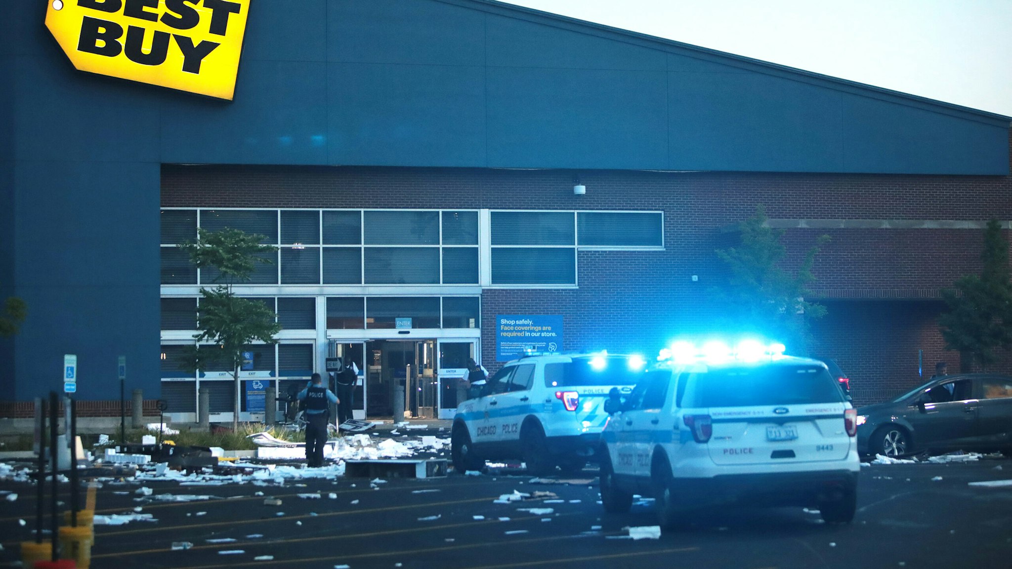 CHICAGO, ILLINOIS - AUGUST 10: A Police officers inspect a damaged Best Buy store after parts of the city had widespread looting and vandalism, on August 10, 2020 in Chicago, Illinois. Police made several arrests during the night of unrest and recovered at least one firearm.