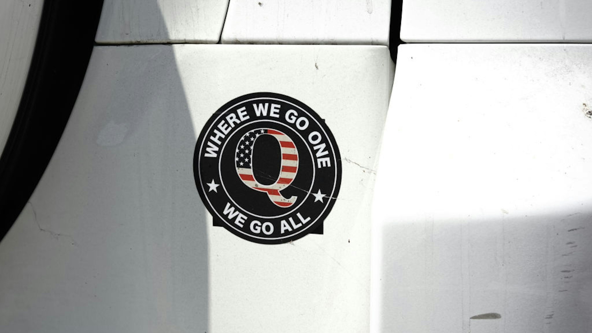 A QAnon bumper sticker is seen on a car outside a campaign rally for U.S. President Donald Trump at Yuma International Airport in Yuma, Arizona, U.S., on Tuesday, Aug. 18, 2020. Trump portrayed Joe Biden as soft on illegal immigration in a speech Tuesday afternoon near the southern U.S. border, reprising a central theme of his 2016 campaign. Photographer: Bing Guan/Bloomberg via Getty Images