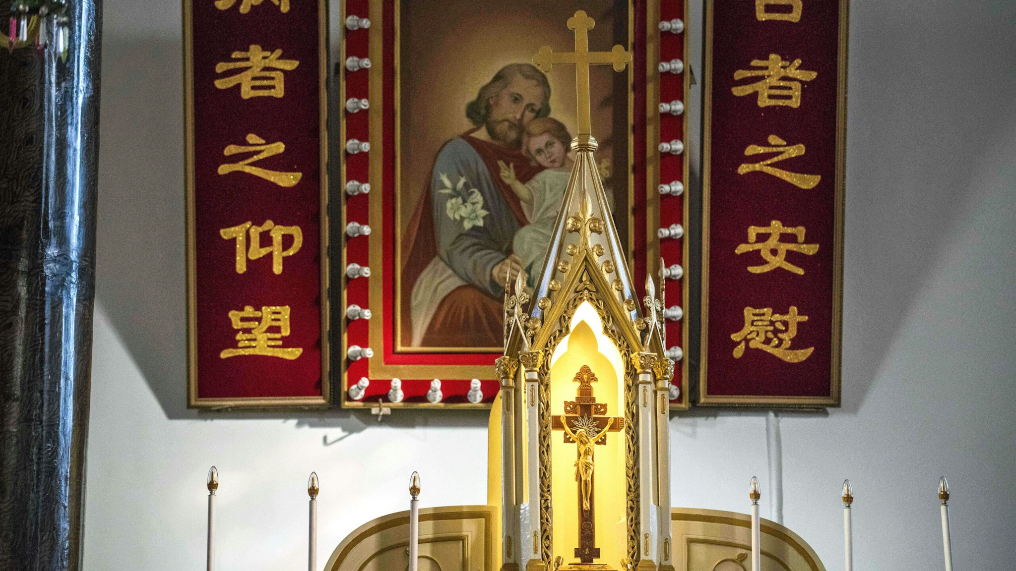 A cross with Jesus (front) and a painting with Joseph and Jesus (back) are seen inside St. Joseph's church, also known as Wangfujing church, in Beijing on January 25, 2018.