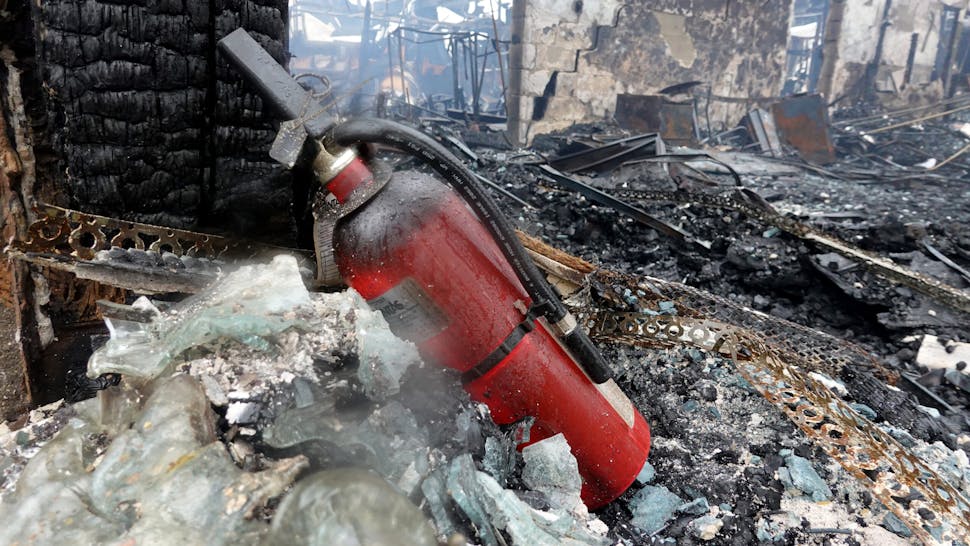 KENOSHA, WISCONSIN - AUGUST 25: A fire extinguisher sits among the rubble of an office furniture store that was torched the previous evening during another night of unrest on August 25, 2020 in Kenosha, Wisconsin.