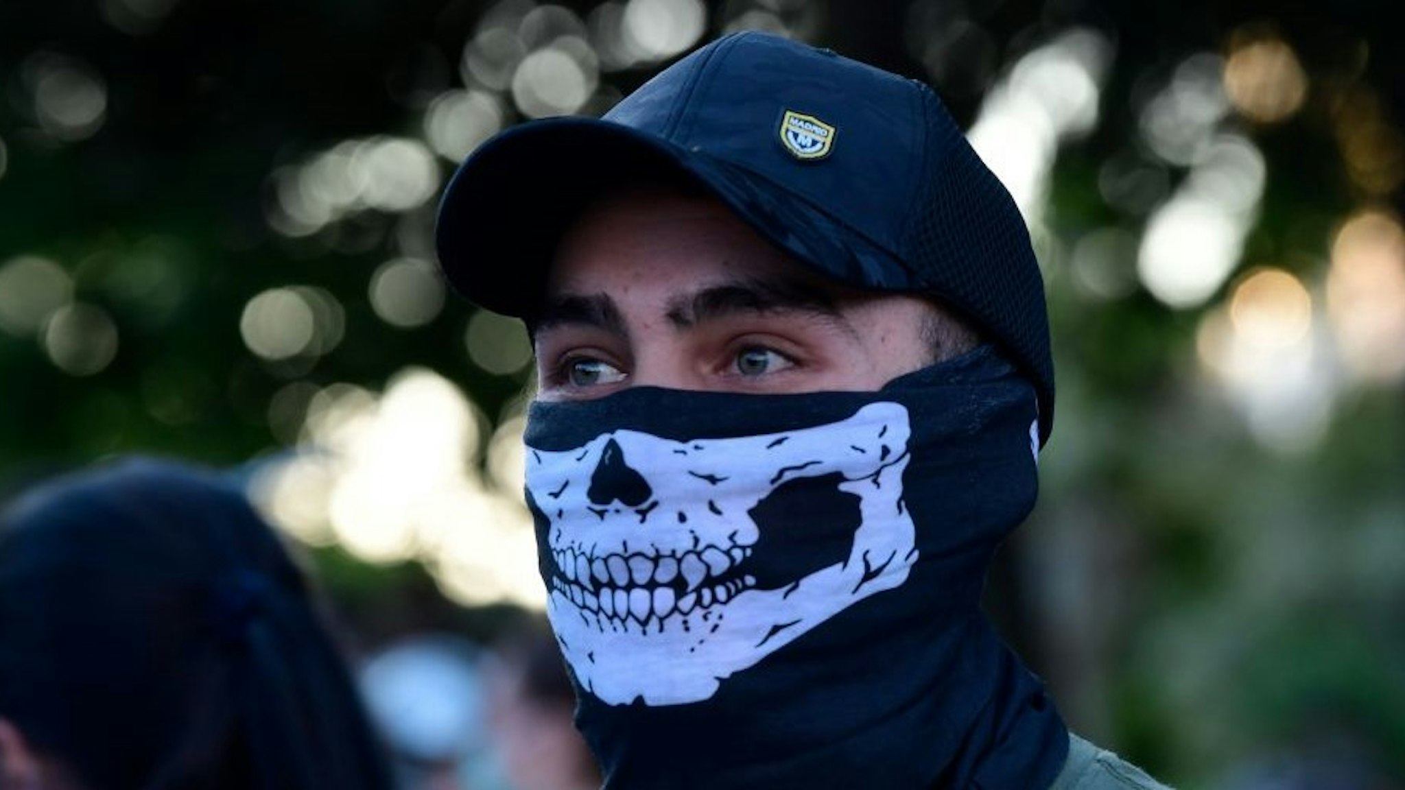 A demonstrator covers his face with a neck gaiter as he takes part in a demonstration against the government's handling of the coronavirus crisis, on May 20, 2020, in Alcorcon, near Madrid. - Spain's prime minister won parliamentary backing extend the lockdown for another two weeks today, despite opposition from his rightwing opponents and protests against his minority coalition government. It was the fifth time the state of emergency has been renewed, meaning the restrictions will remain in force until June 6 in a measure passed by 177 votes in favour, 162 against and 11 abstentions. (Photo by JAVIER SORIANO / AFP) (Photo by