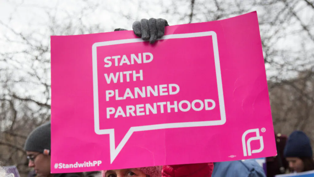 NEW YORK, NY - APRIL 1: A health care activist lifts signage promoting Planned Parenthood during a rally as part of the national "March for Health" movement in front of Trump Tower on April 1, 2017 in New York City.